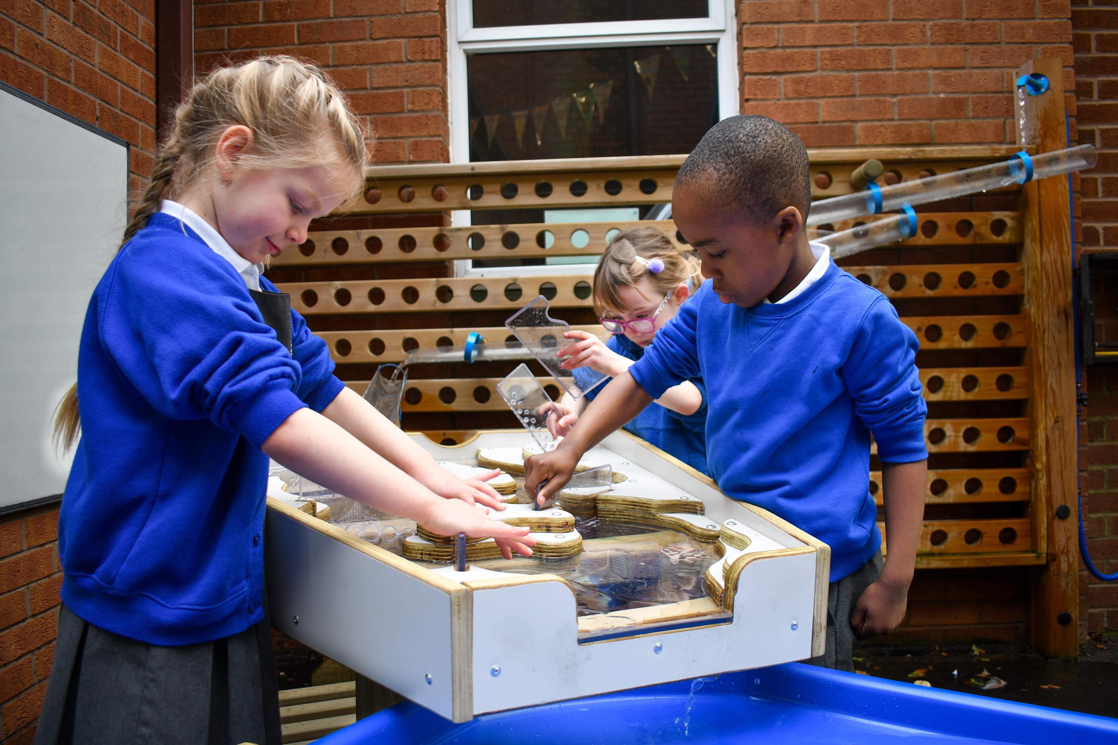 Children using mud sand and water to play on our damming station