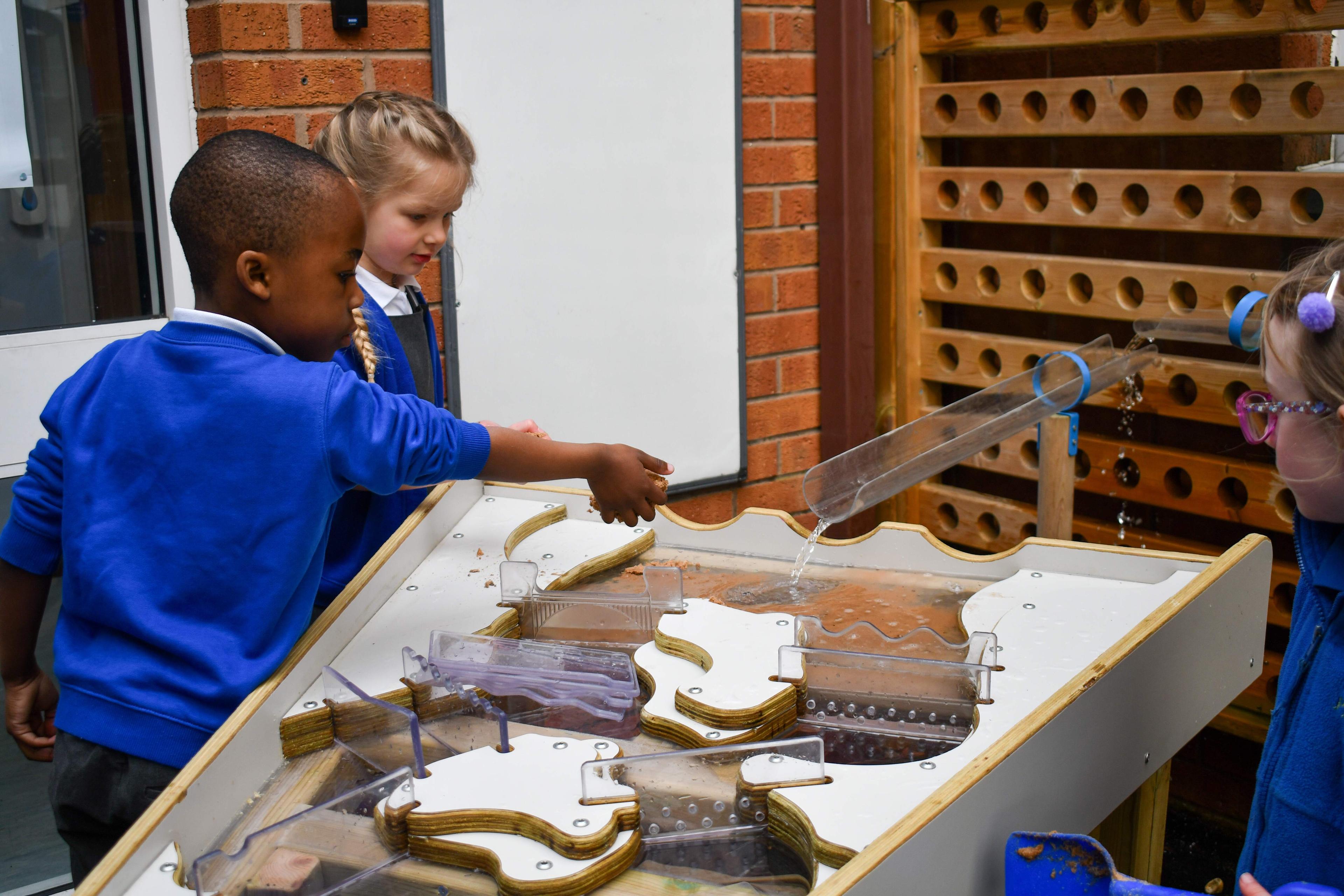Children playing with the plywood damming features