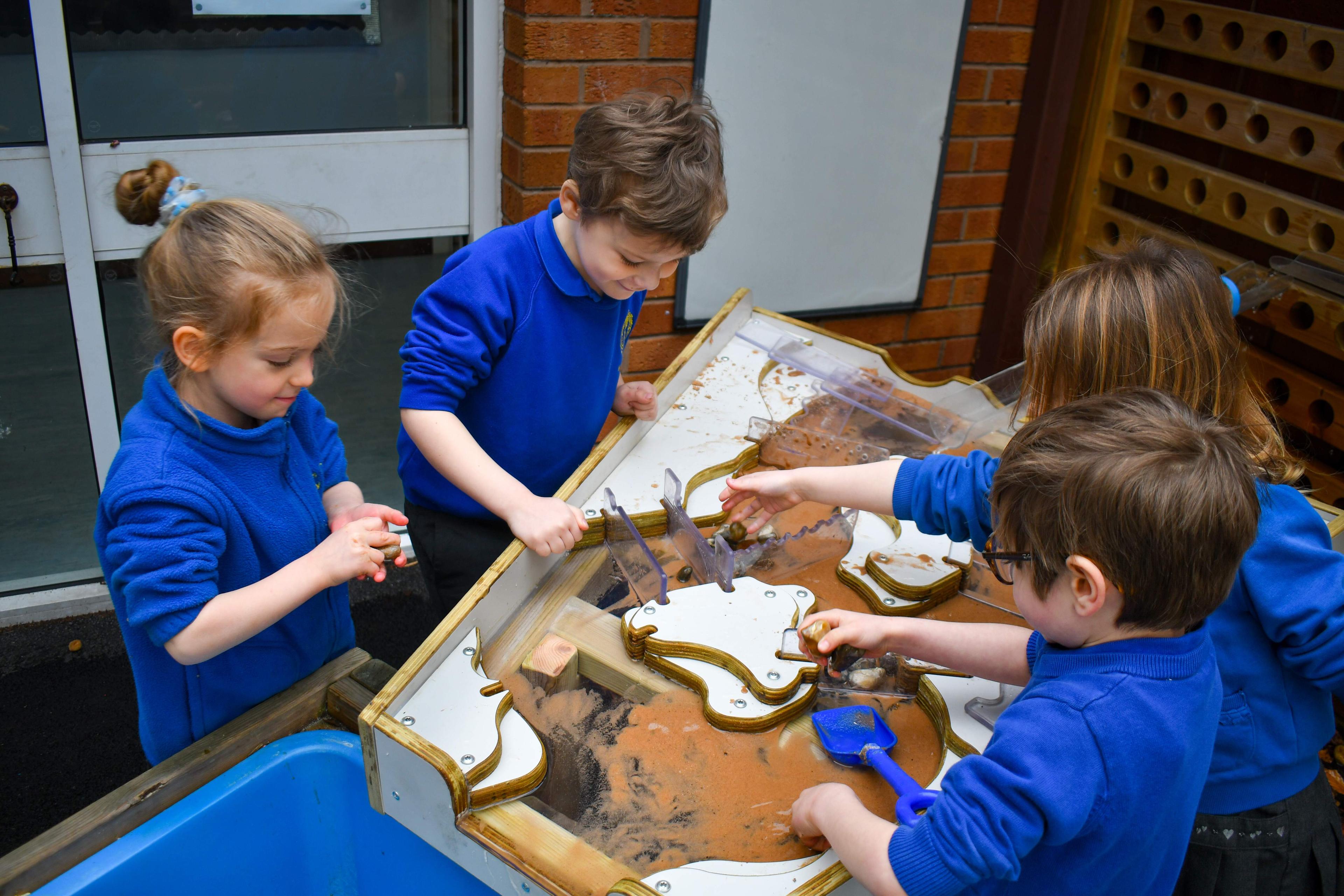 Children using mud sand and water to play on our damming station