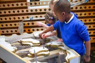 a group of children playing with the damming station