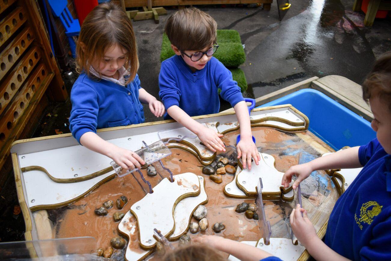 a group of children playing with the damming station