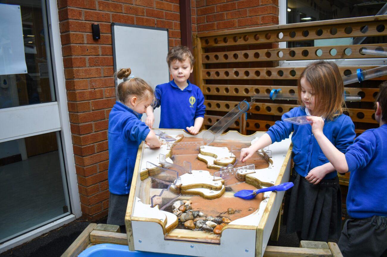 a group of children playing with the damming station