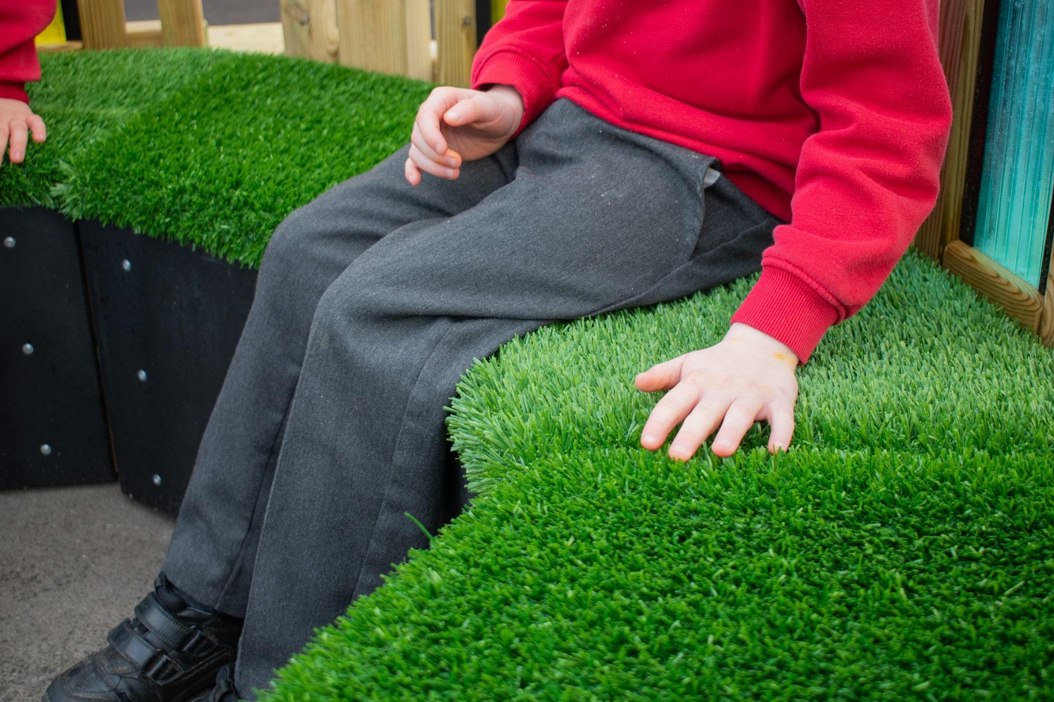 Boy Touching Artificial Grass on Sensory Seating Circle