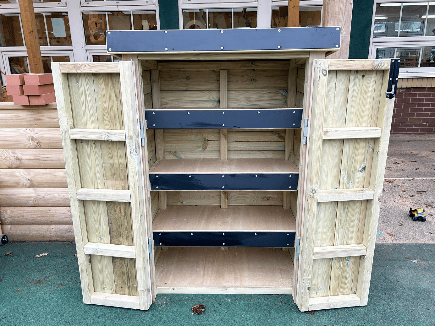 An open wooden Acorn Storage Unit in a school playground