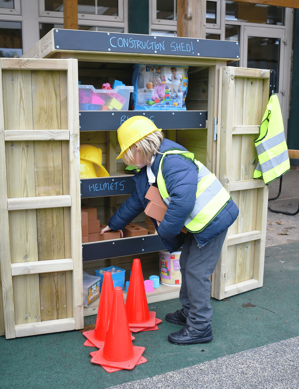A school child taking provisions out of a wooden Acorn Self Select Storage Unit
