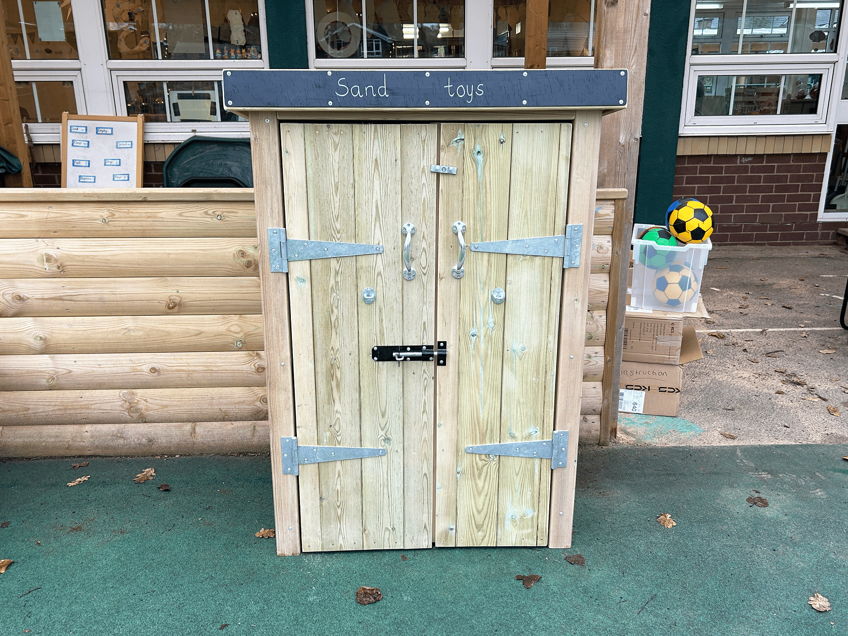 An closed wooden Acorn Self Select Storage unit in a playground.