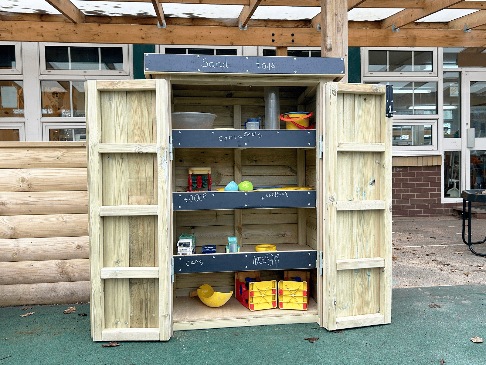 An open wooden Acorn Self Select Storage unit in a playground.