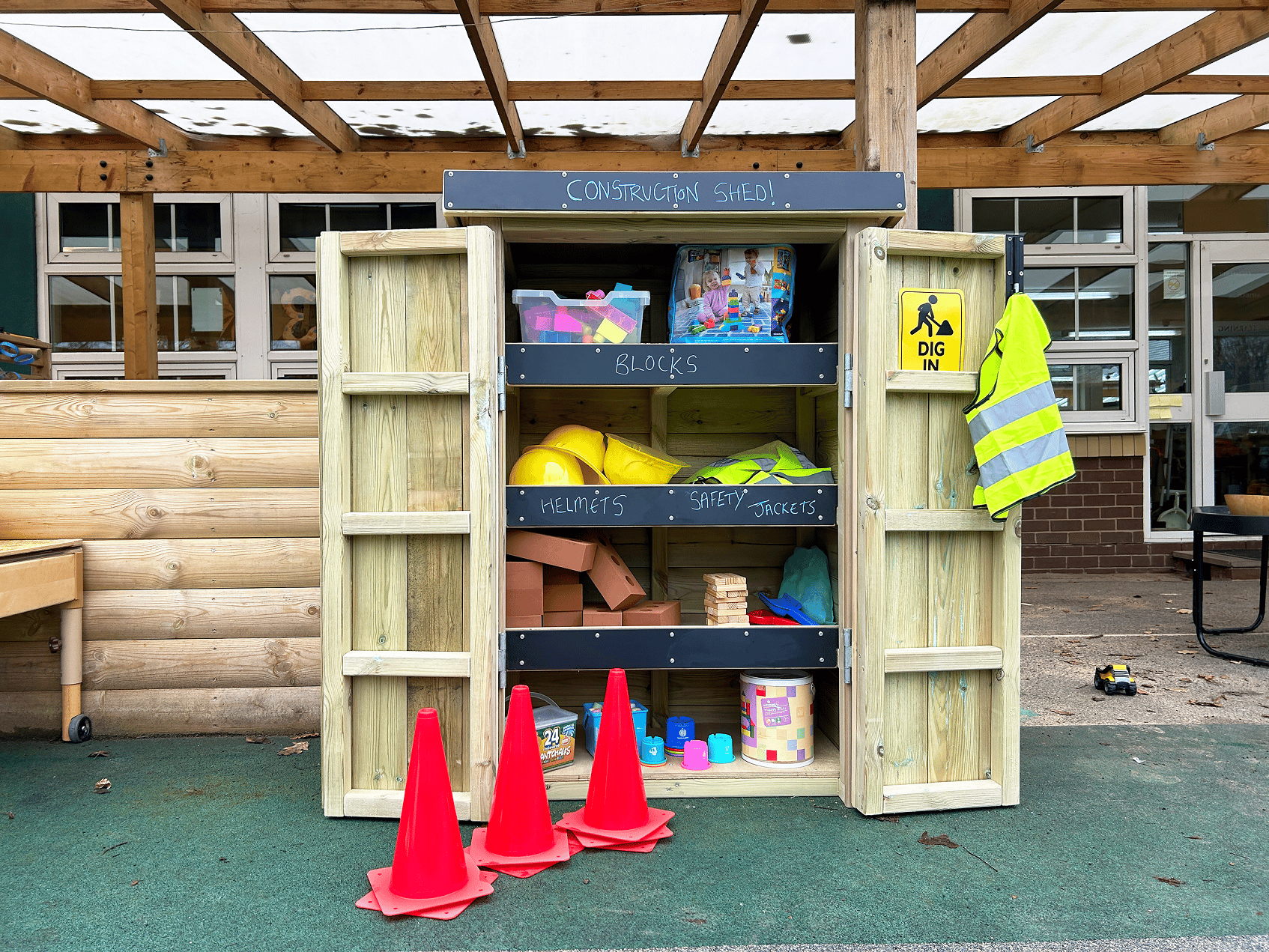 An open wooden Acorn Self Select Storage unit with toys in it.