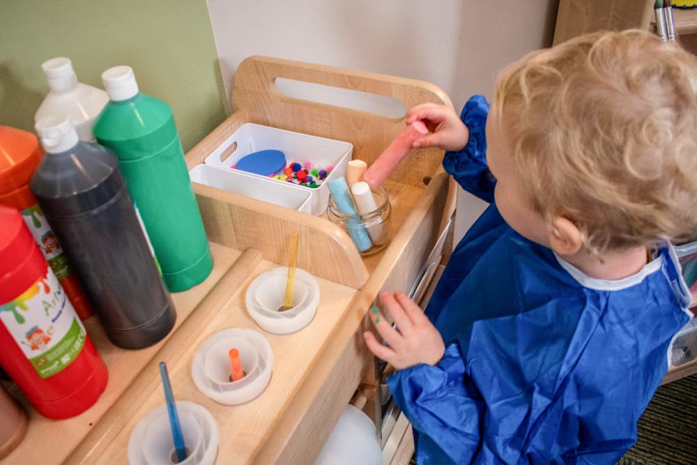 Child painting on Millhouse Continuous Provision Trolley