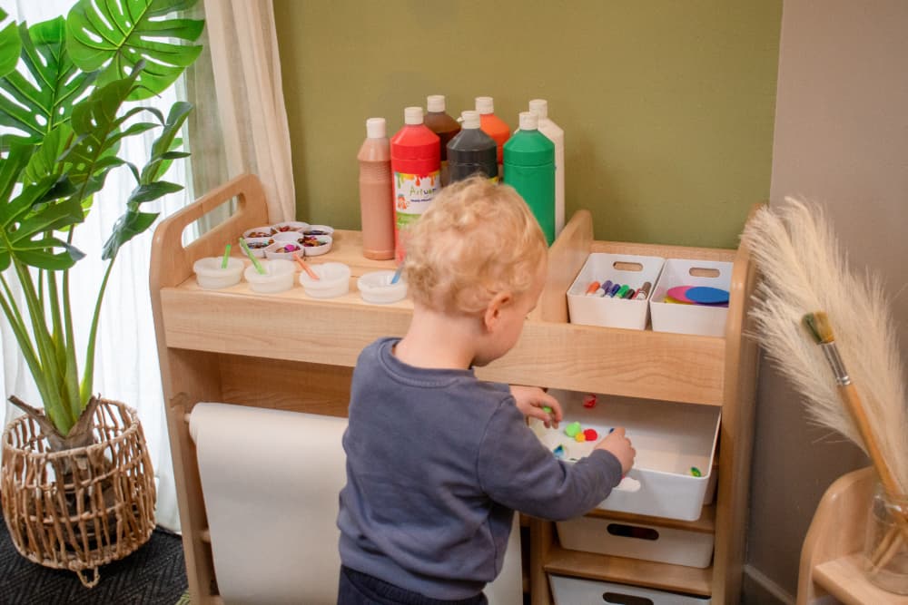 Child getting paper from Millhouse Continuous Provision Trolley