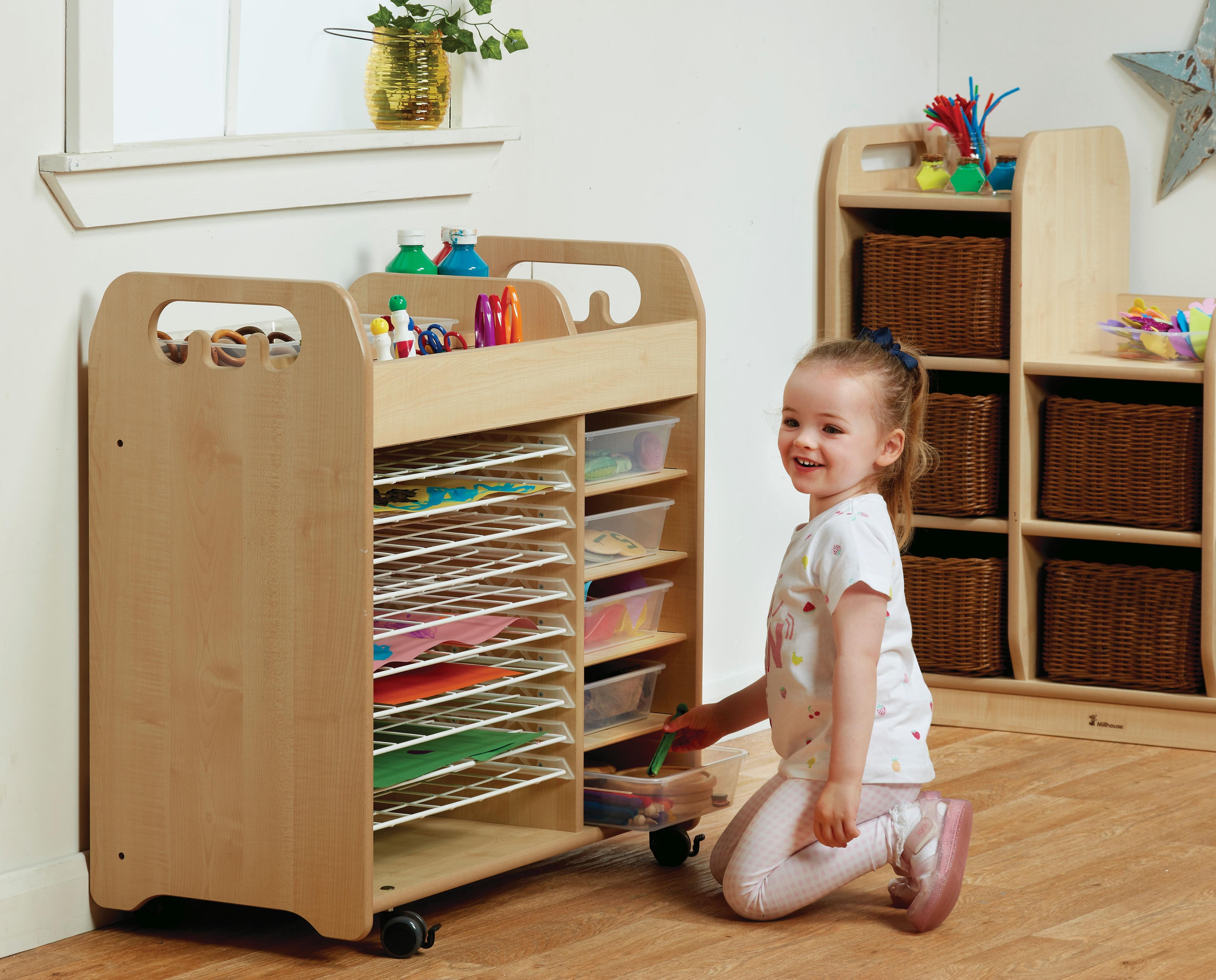 A young girl selecting arts and crafts supplies from the Combi Art Trolley, in a classroom.    