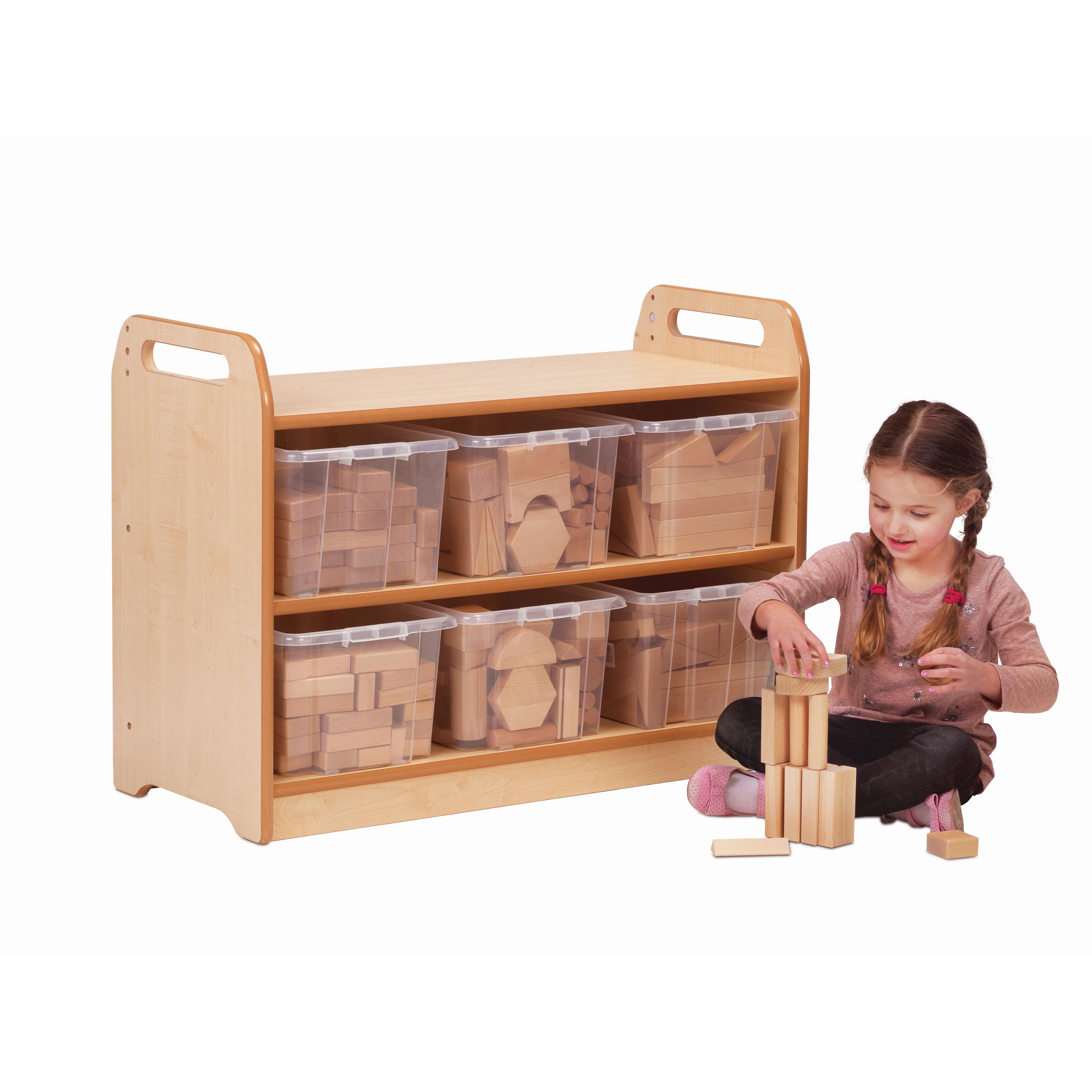 A young girl is building a tower from wooden blocks sat in front of the Block Play Unit with blocks neatly organised inside the six plastic tubs.  
