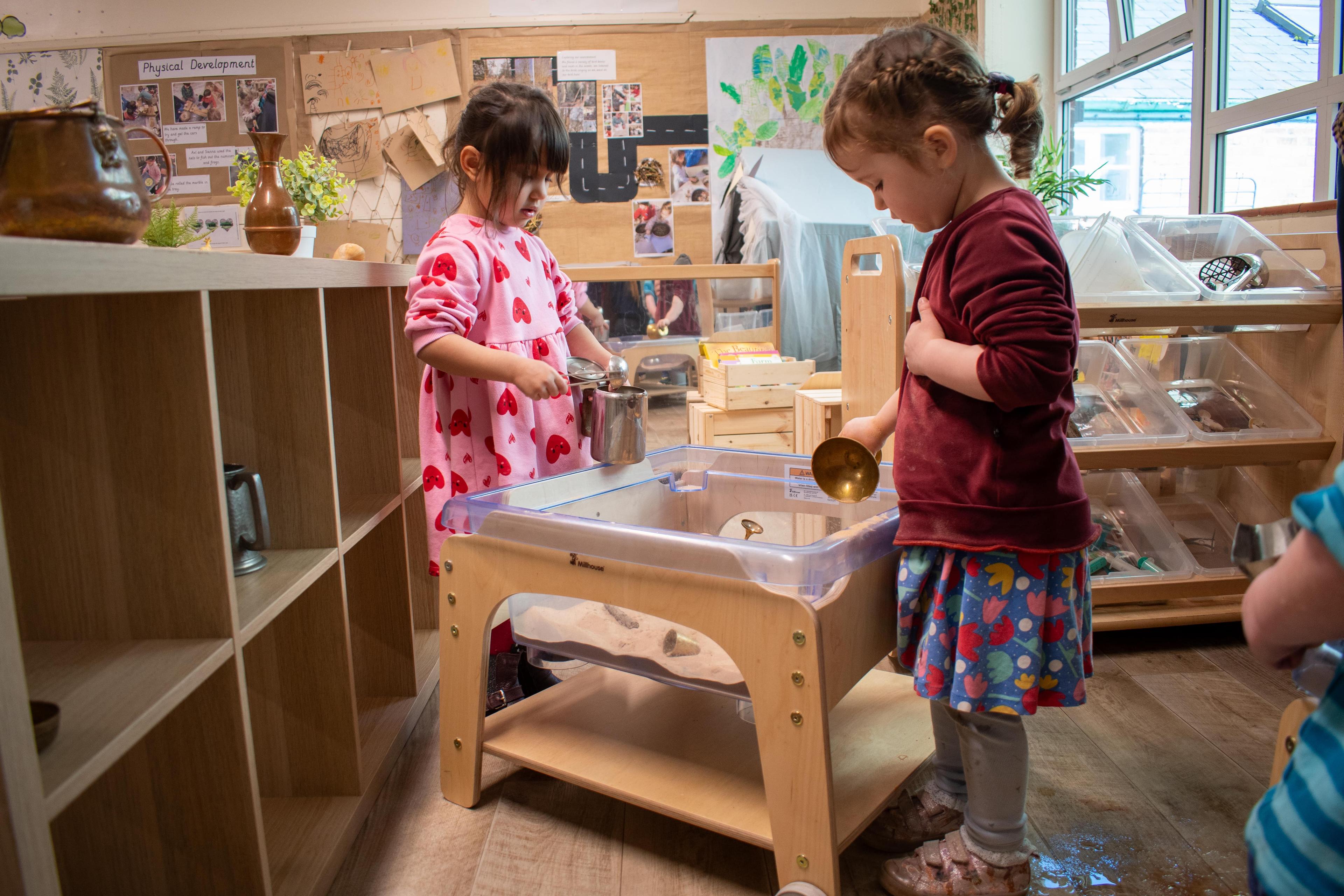 Nursery children playing with the Millhouse sand station