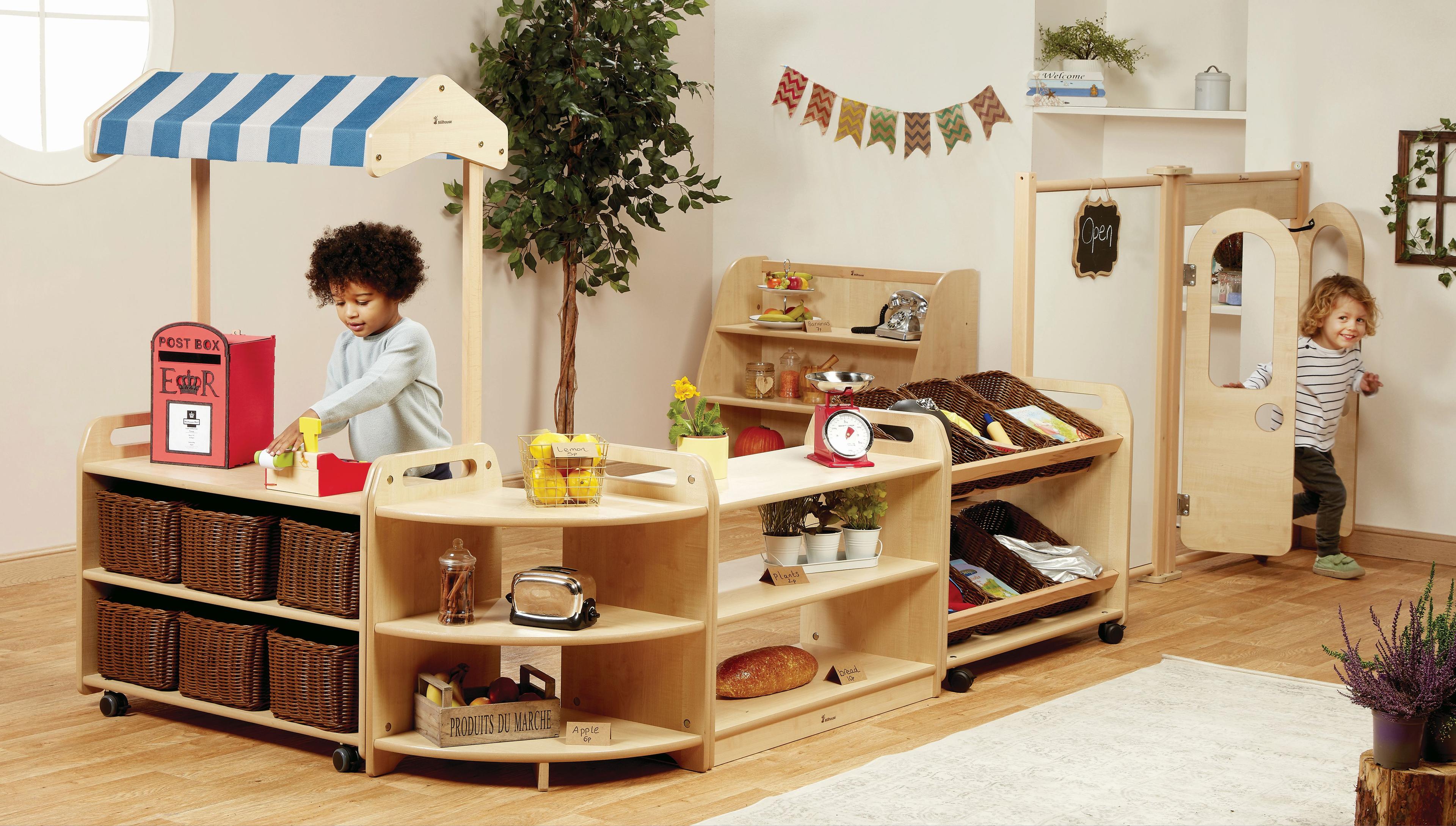 Two boys are playing shops inside the Role Play Zone inside a classroom. 