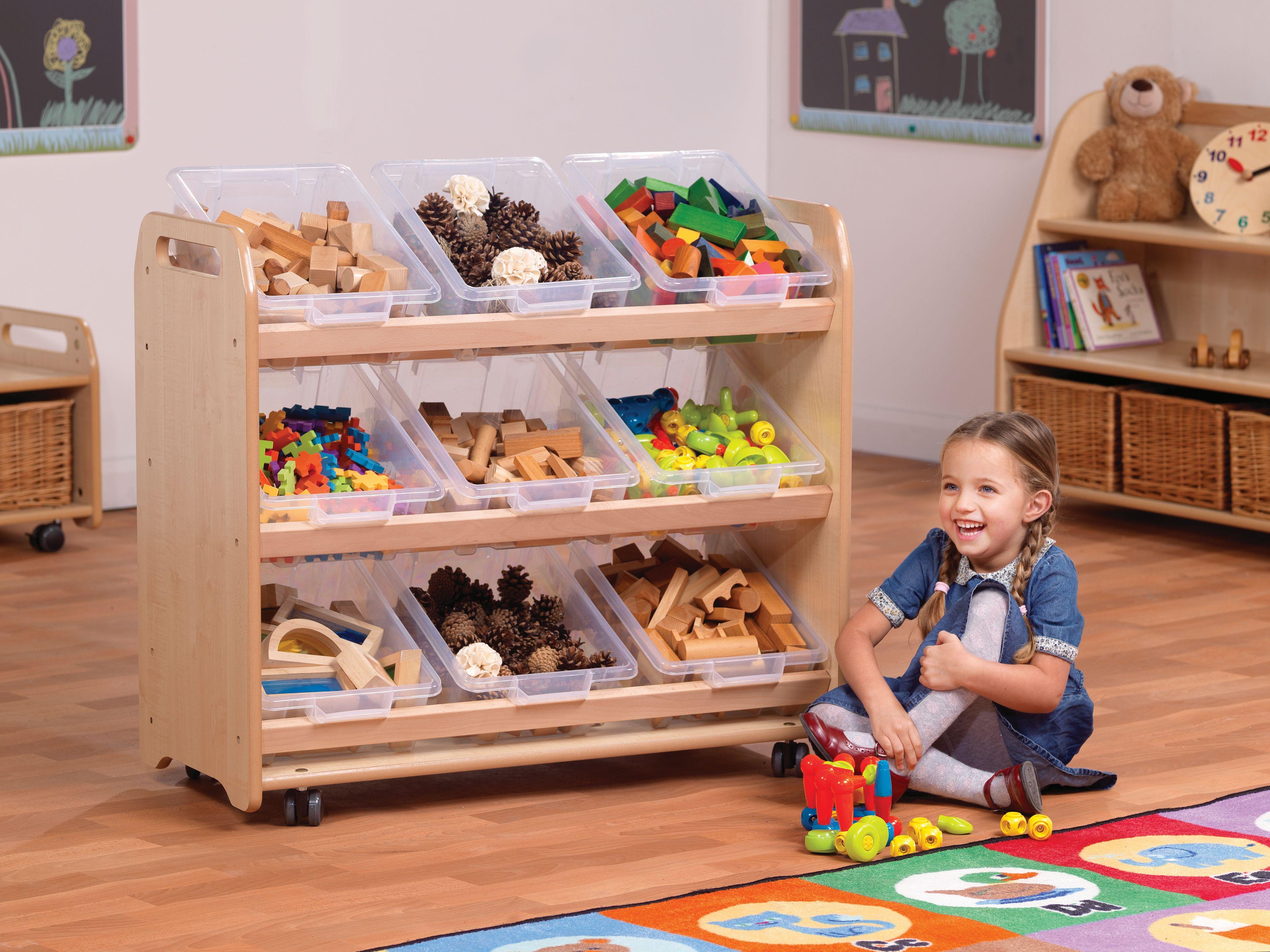 The Tilt Tote Storage with 9 Clear Tubs is full of different resources, a young girl is playing next to it in the classroom.