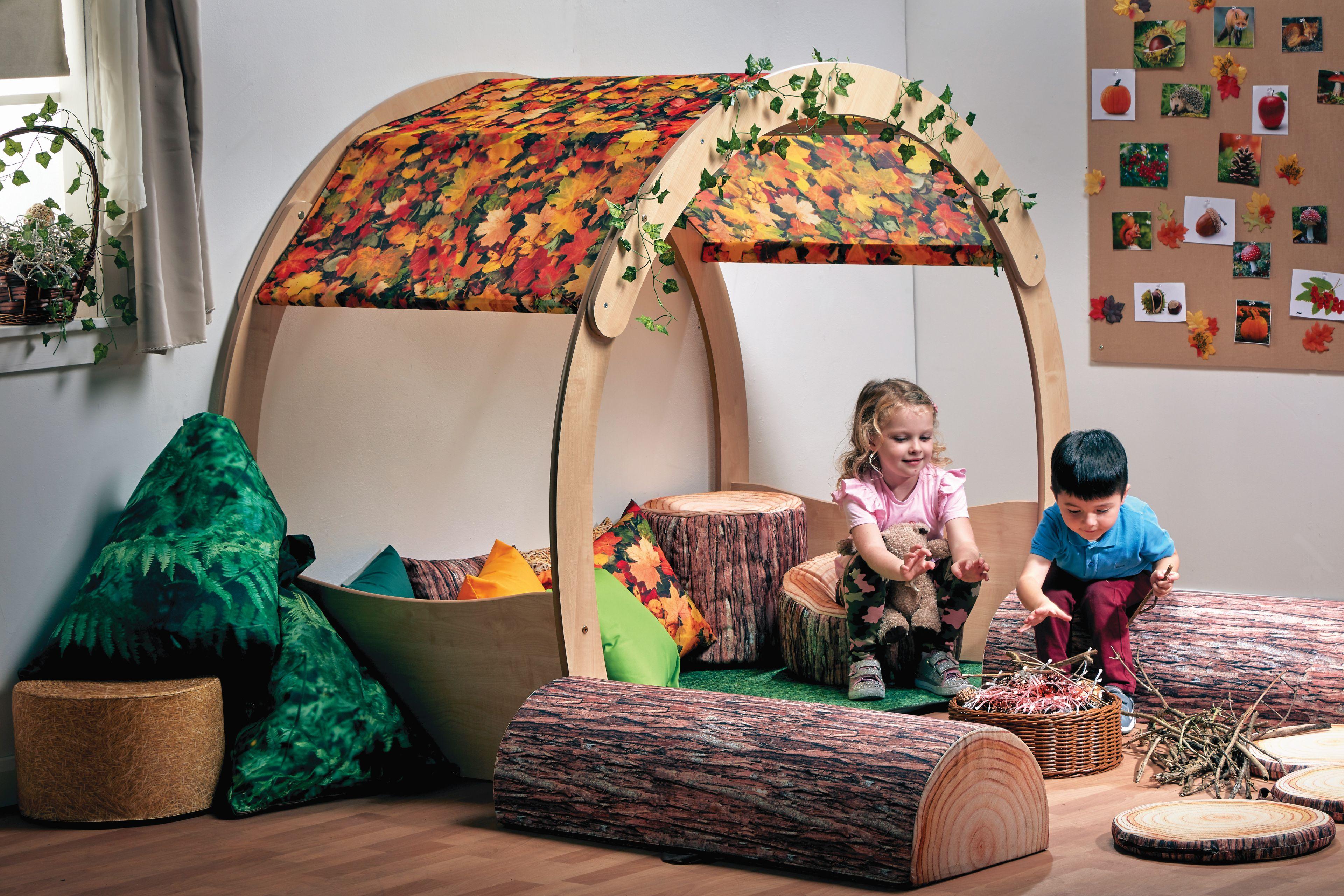 A young girl and boy are playing inside the Large Cosy Cove Plus Autumn Accessory Set in a classroom.