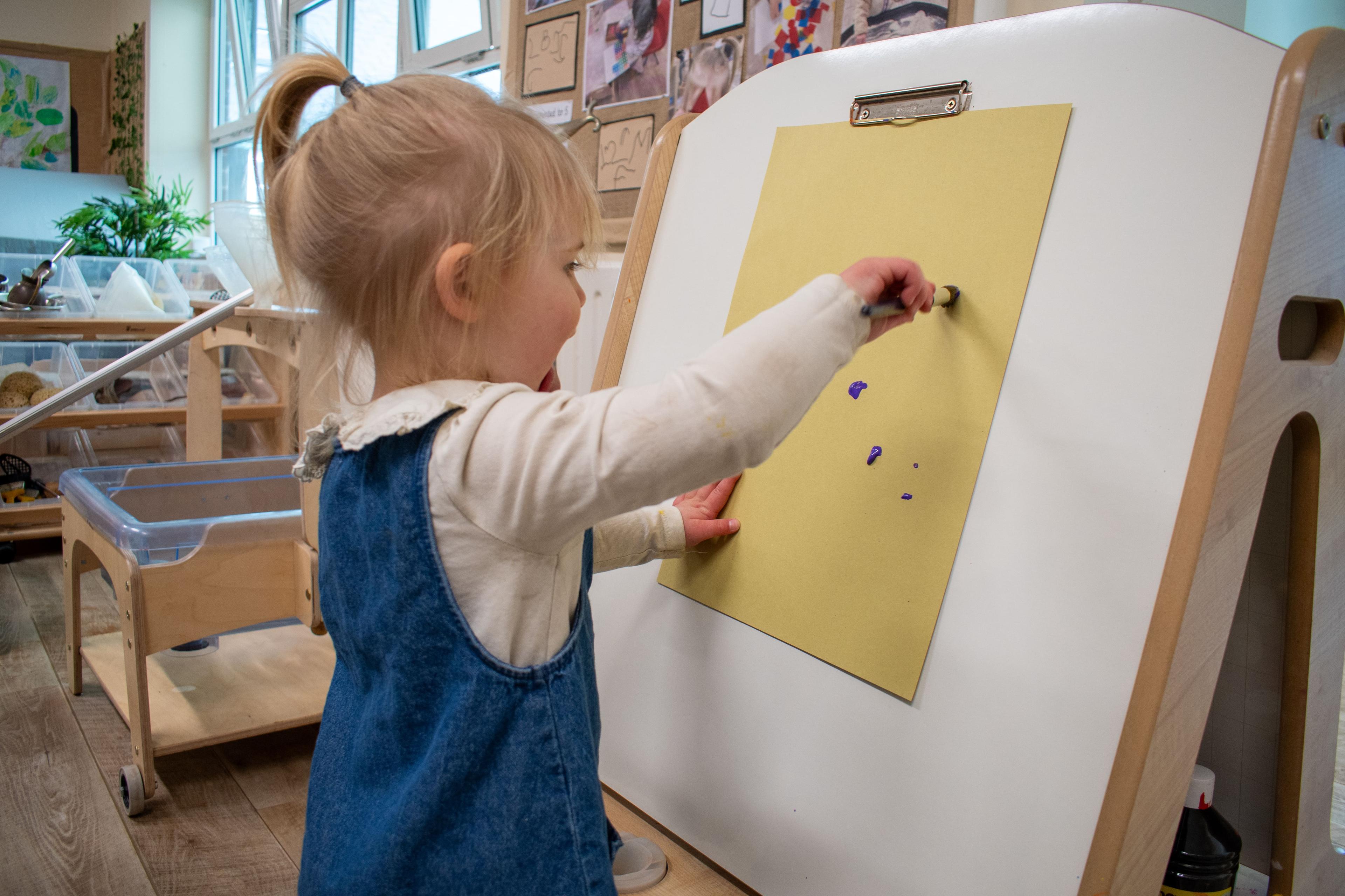 A child painting on her Millhouse Double Sided Easel