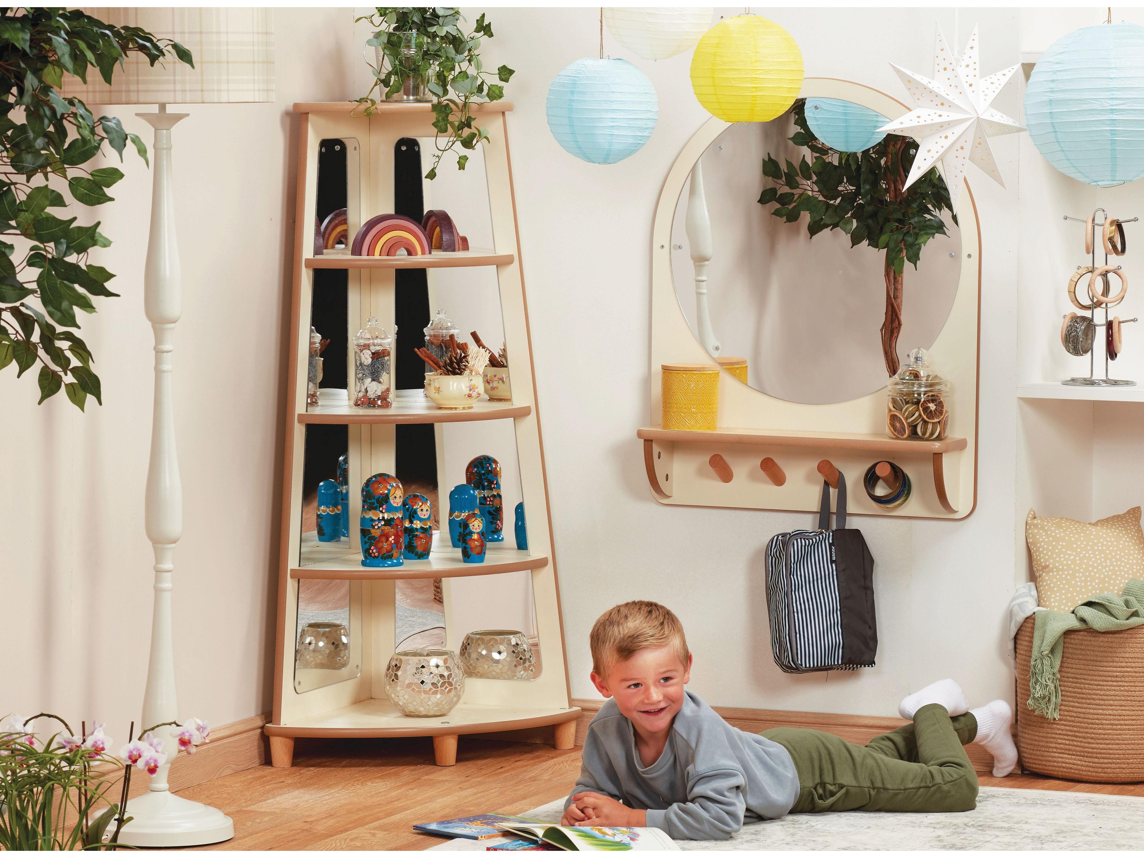 millhouse corner shelving unit in an eyfs setting with trinkets filling each shelf and a child reading in front