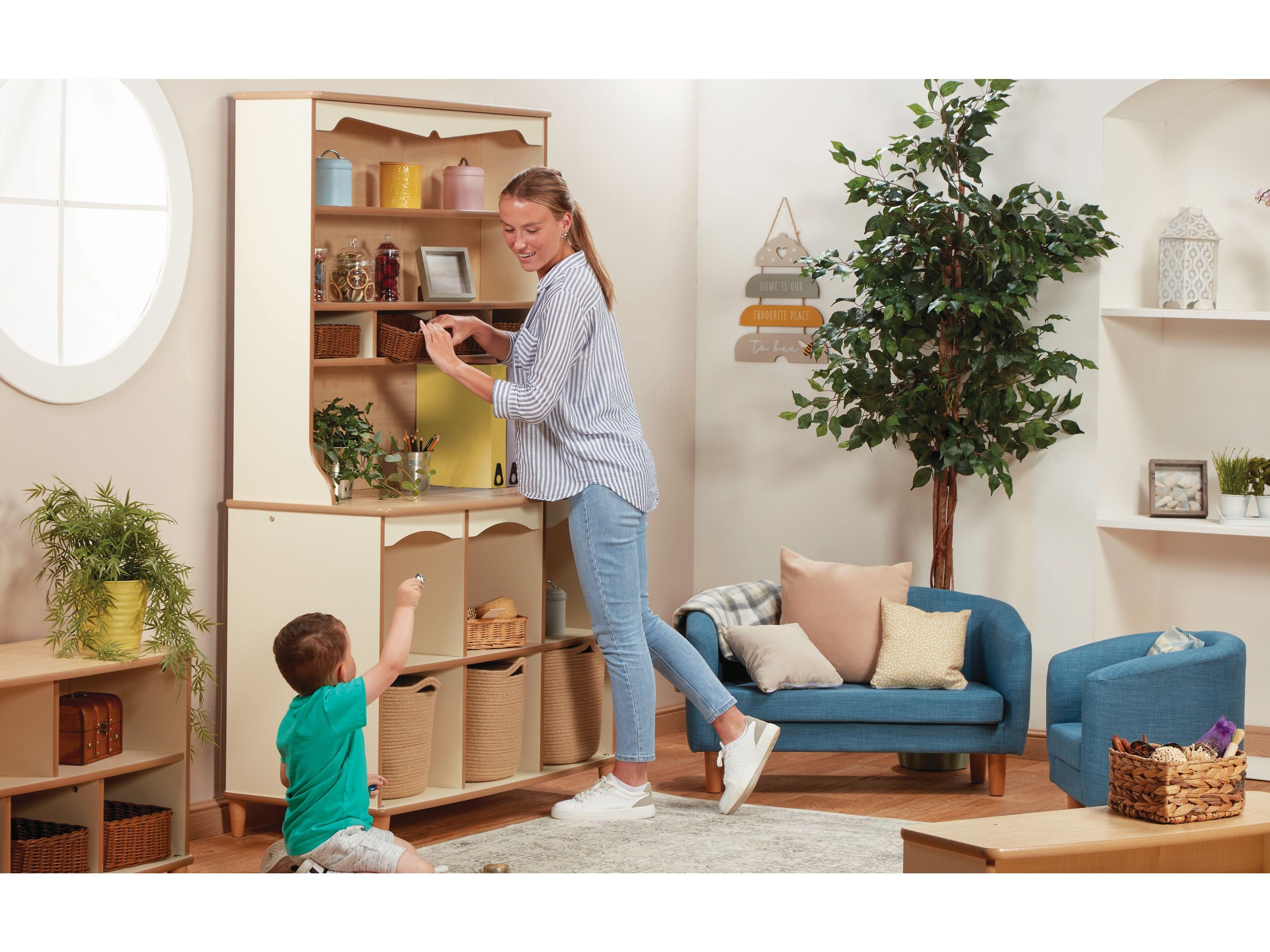 millhouse tall storage dresswe with nursery practitioner reaching for a resource to help a child