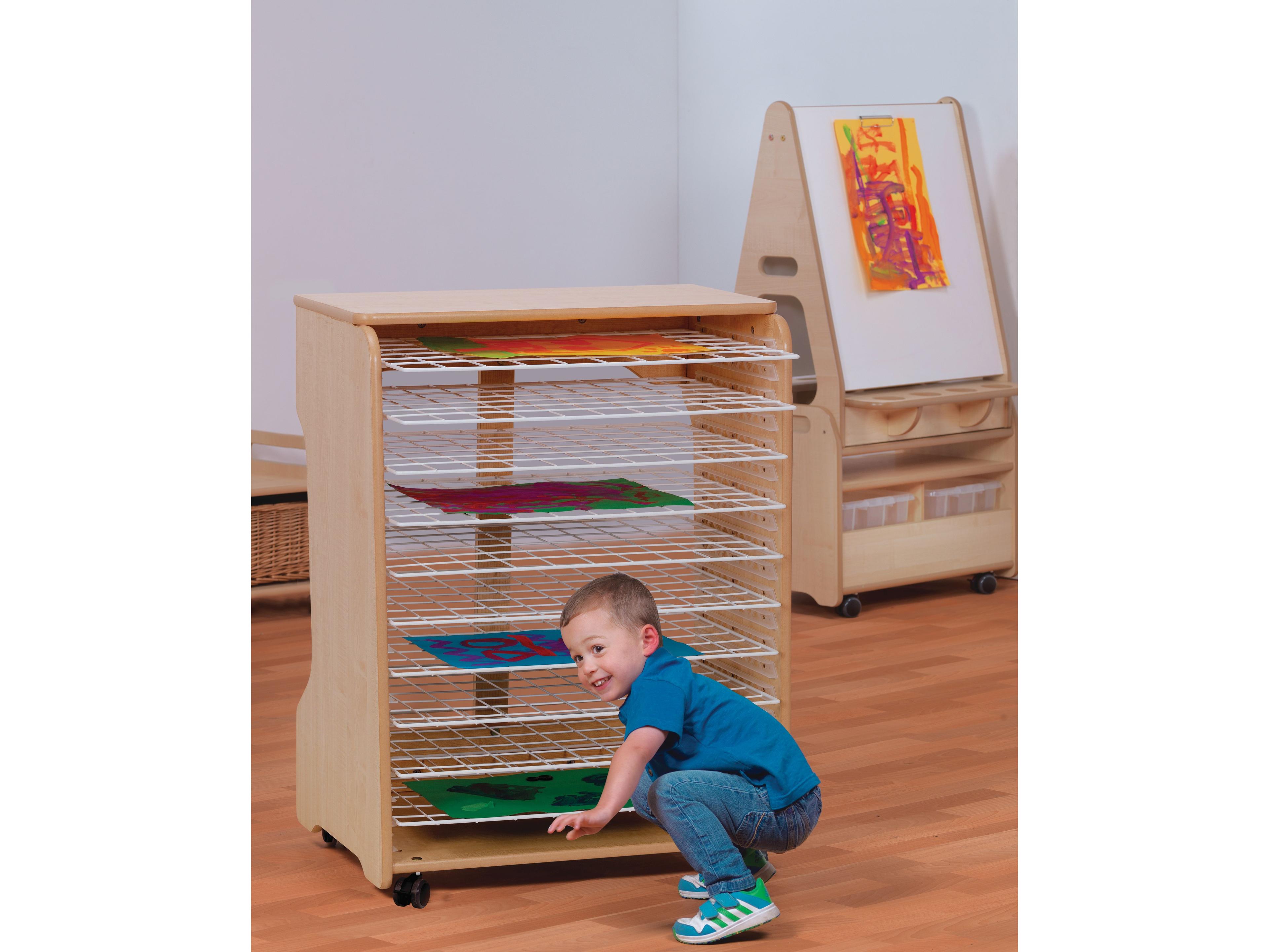 millhouse drying rack in a nursery room with child placing their artwork onto a rack