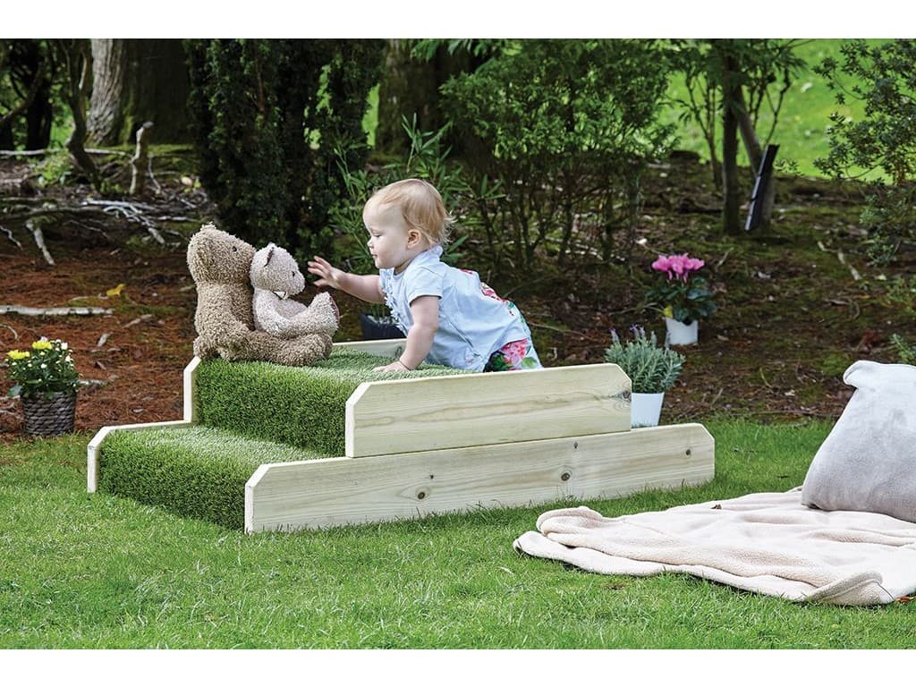 millhouse outdoor stepped unit with artificial grass and a baby crawling on top