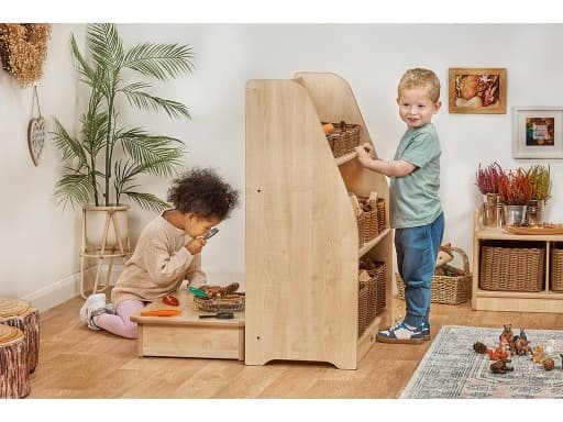 millhouse low table with child exploring items with her magnifying glass on top of the table