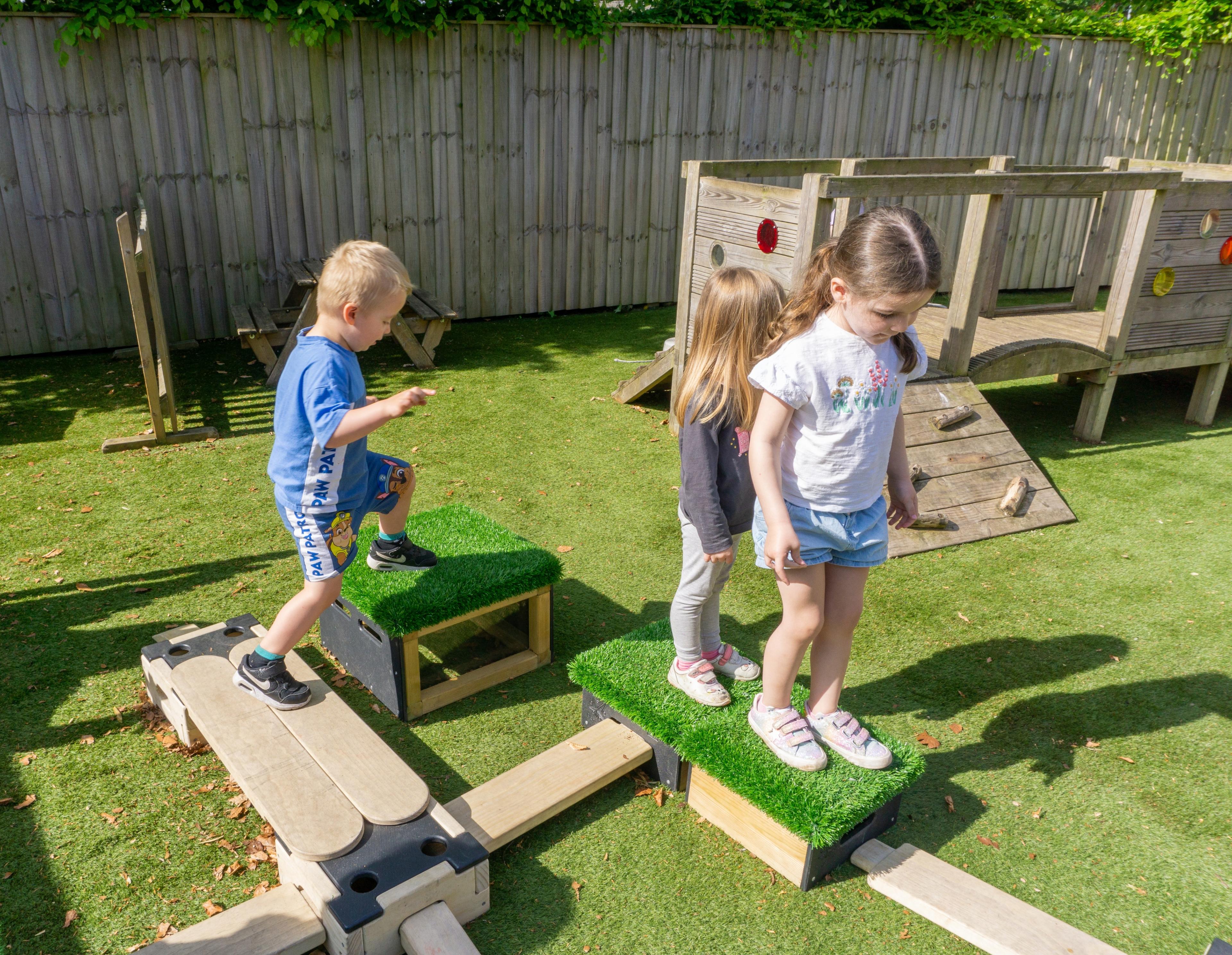 group of children moving across planks and blocks