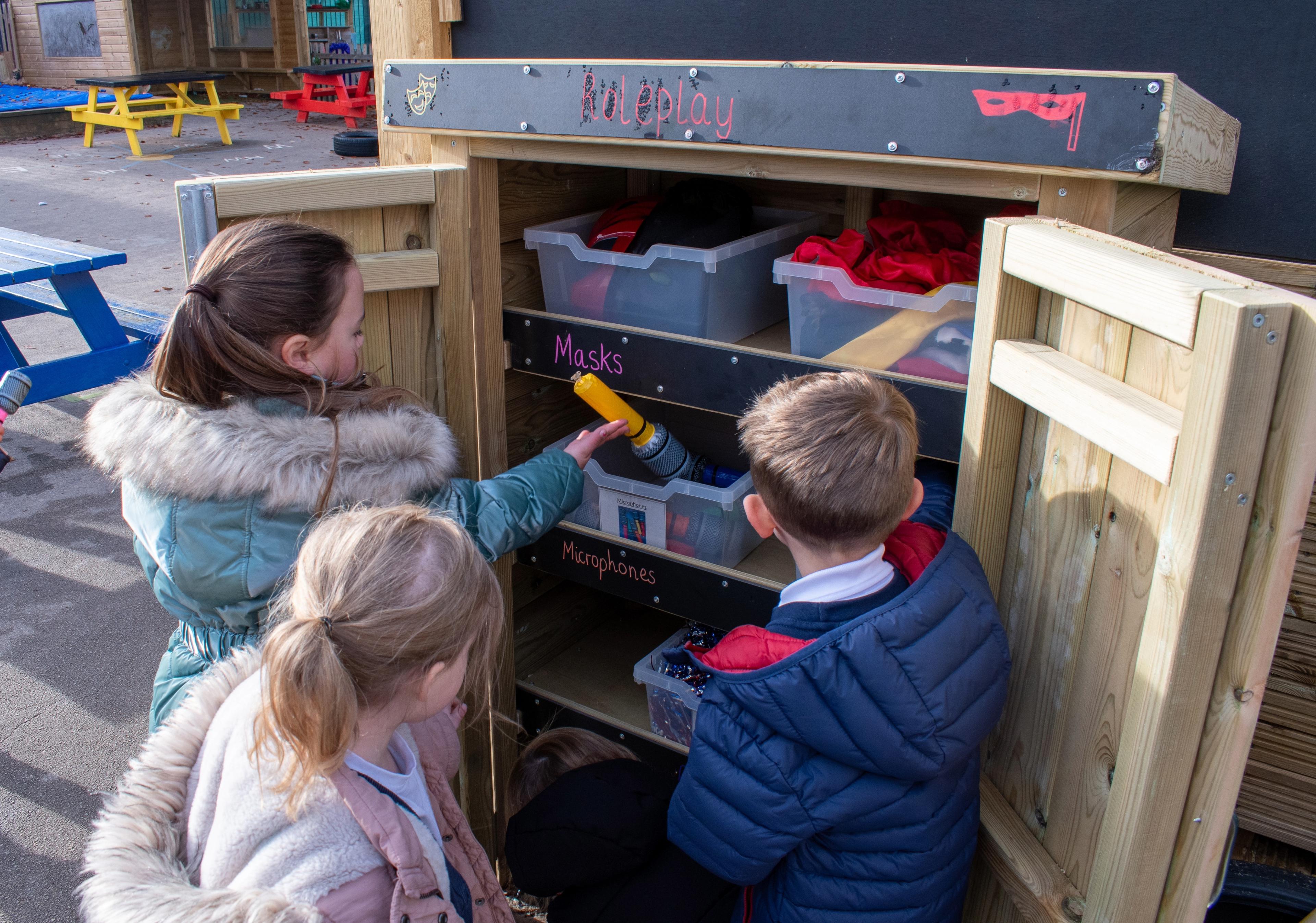 Children selecting toys from a storage unit