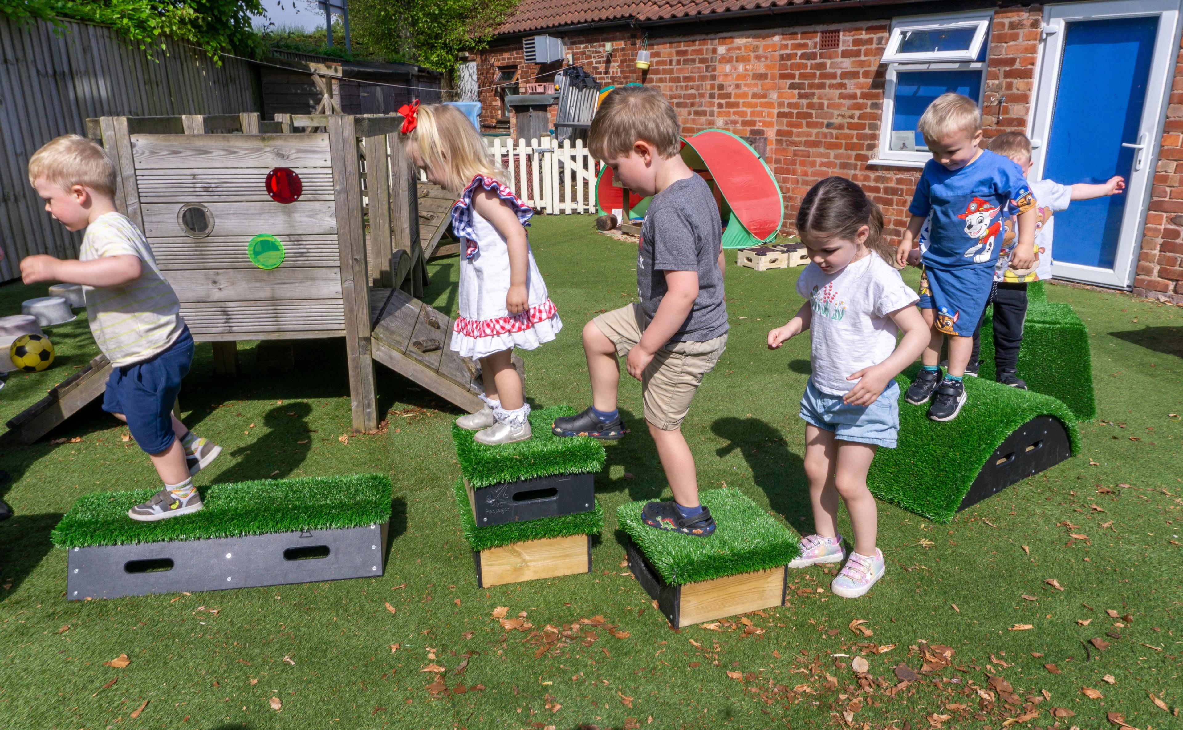 children jumping on grass blocks