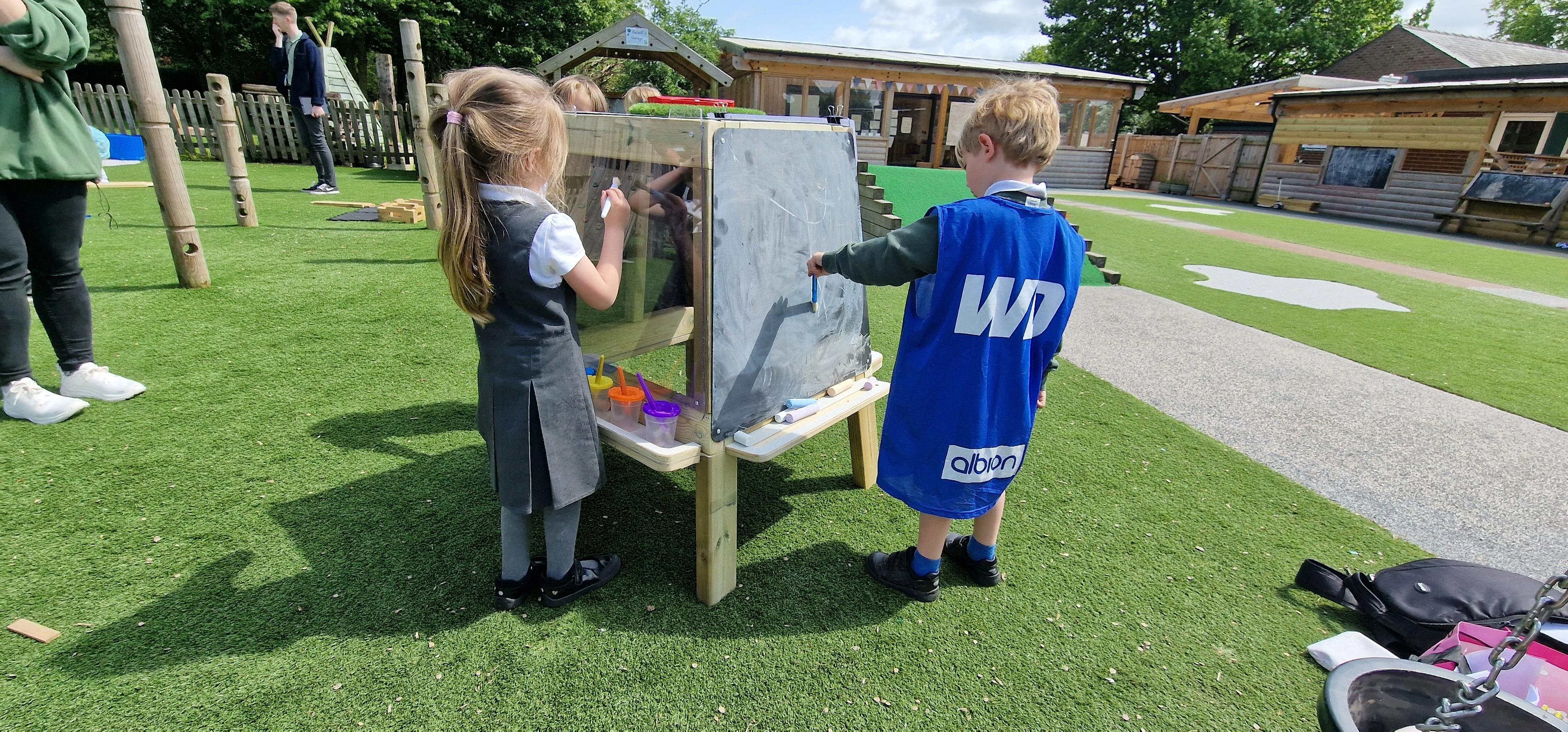 Group of children drawing on an art easel with chalk