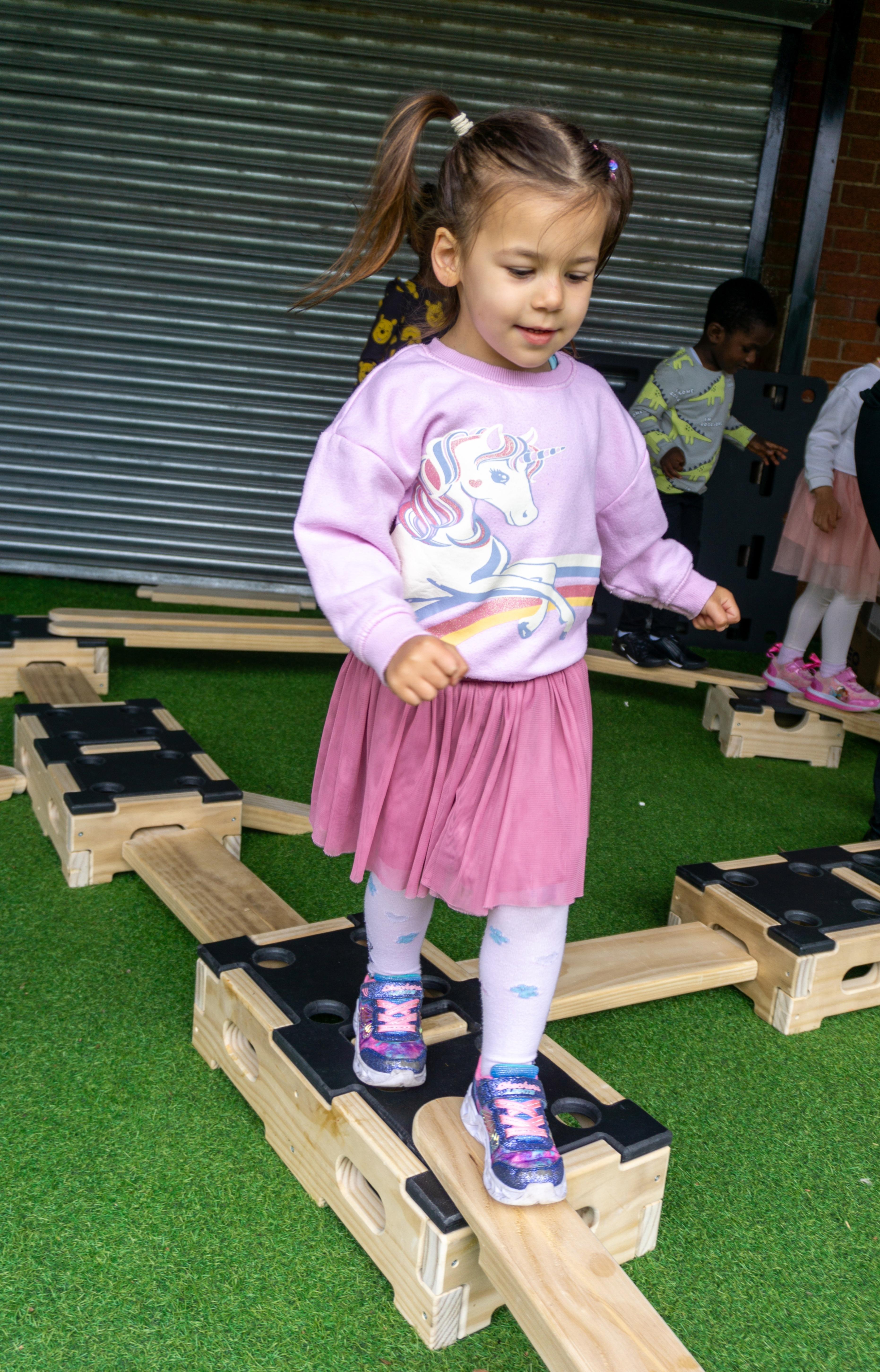 Young girl balancing on a plank