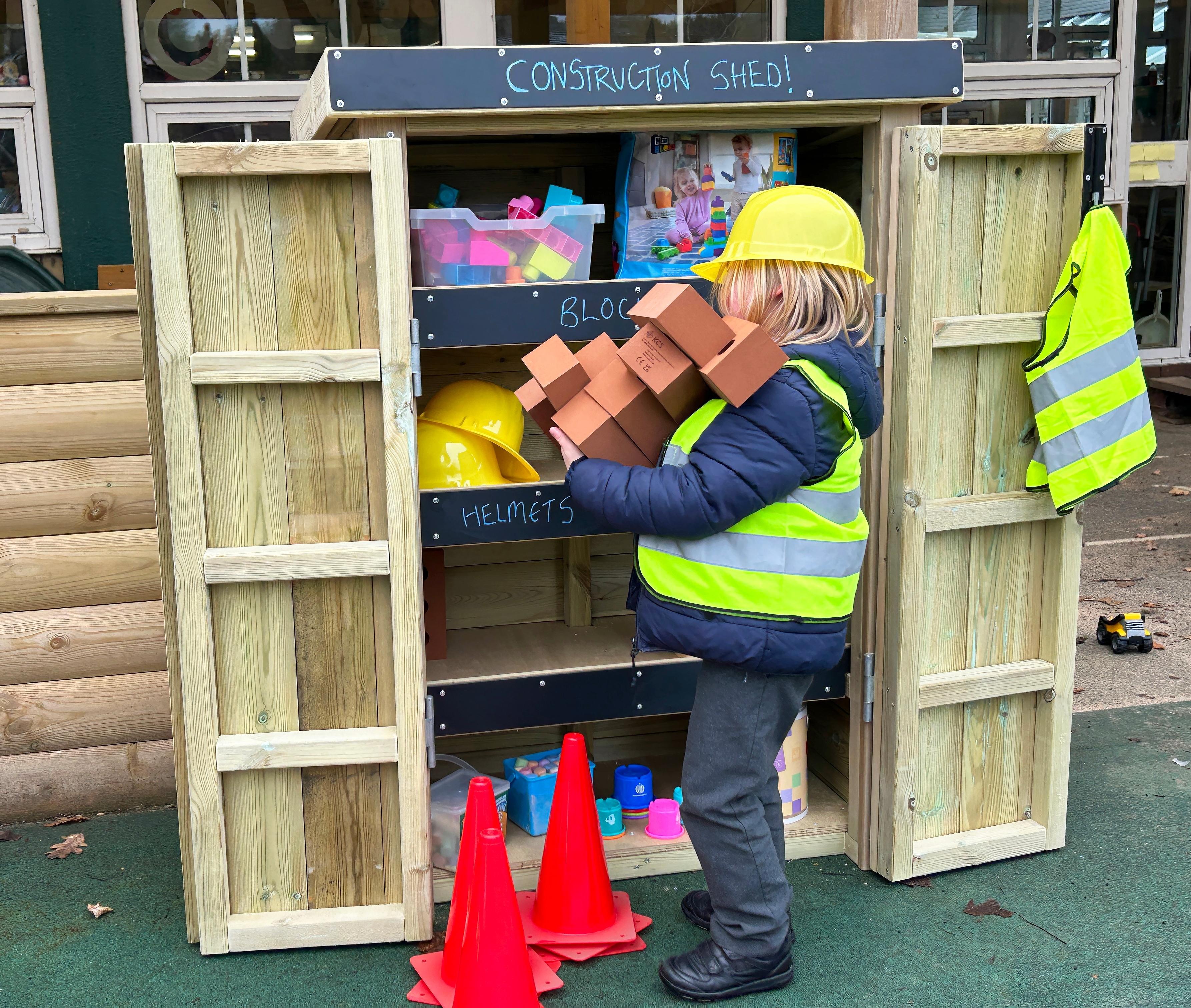 Young boy grabbing toy bricks out of a storage unit