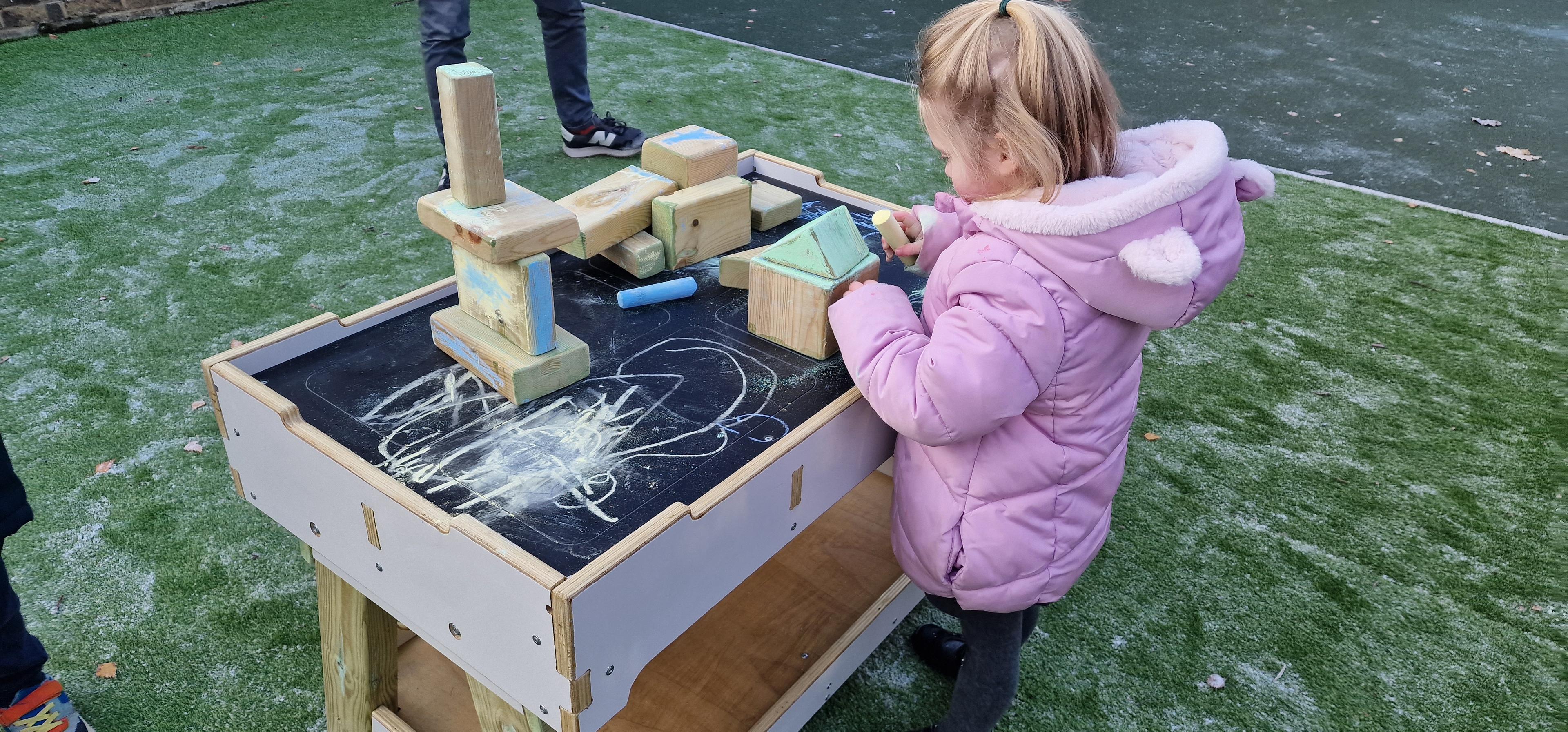 Young girl playing with construction blocks on a table