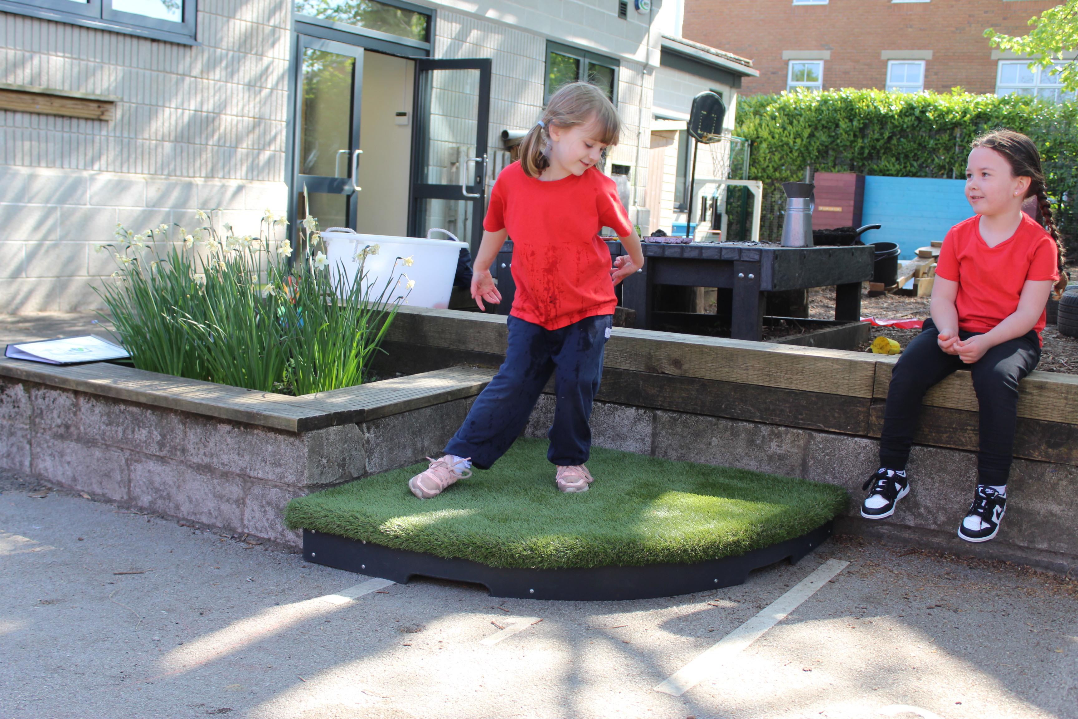 A young girl dancing on a grass stage