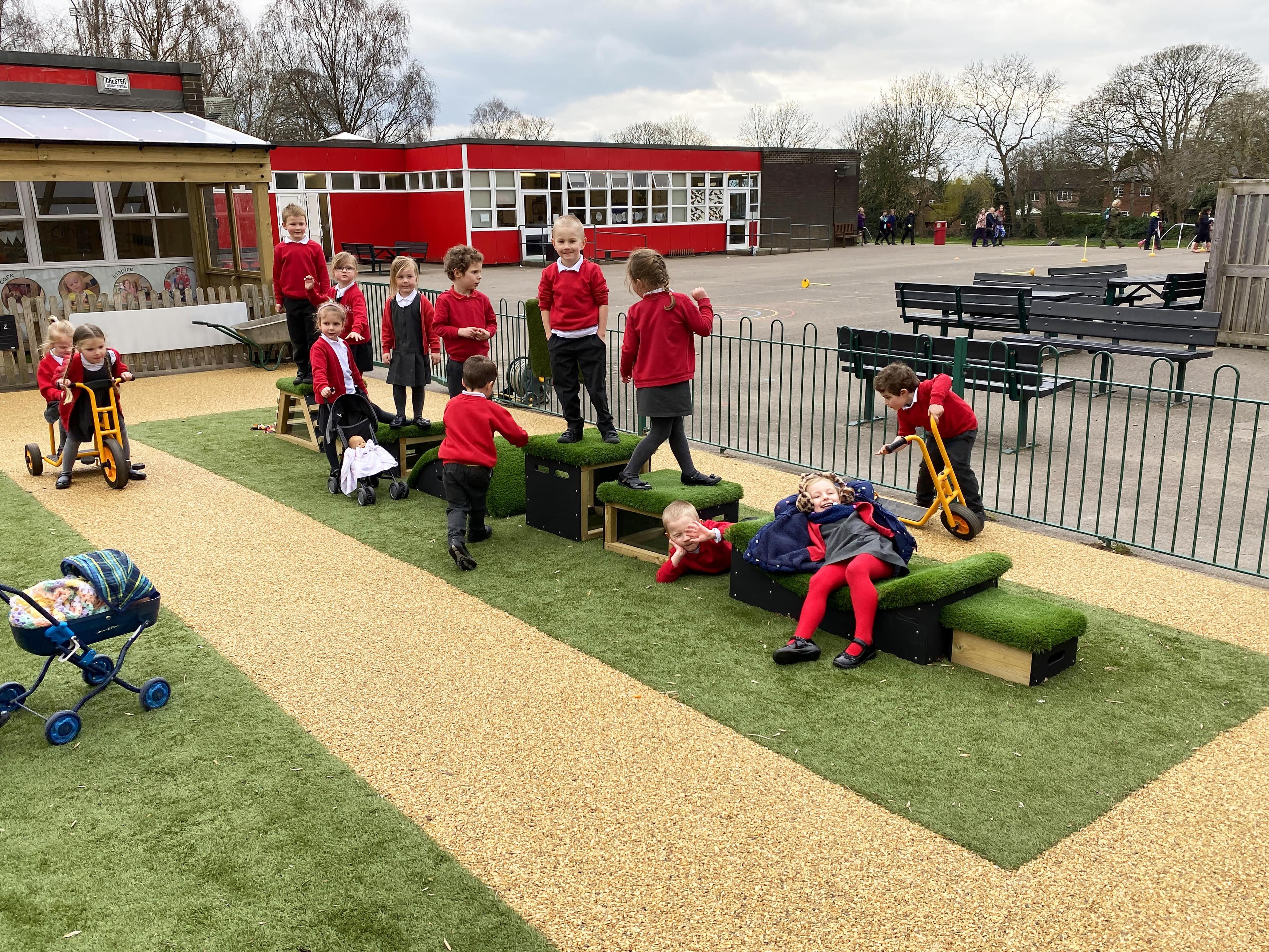 Children moving across grass topped blocks 