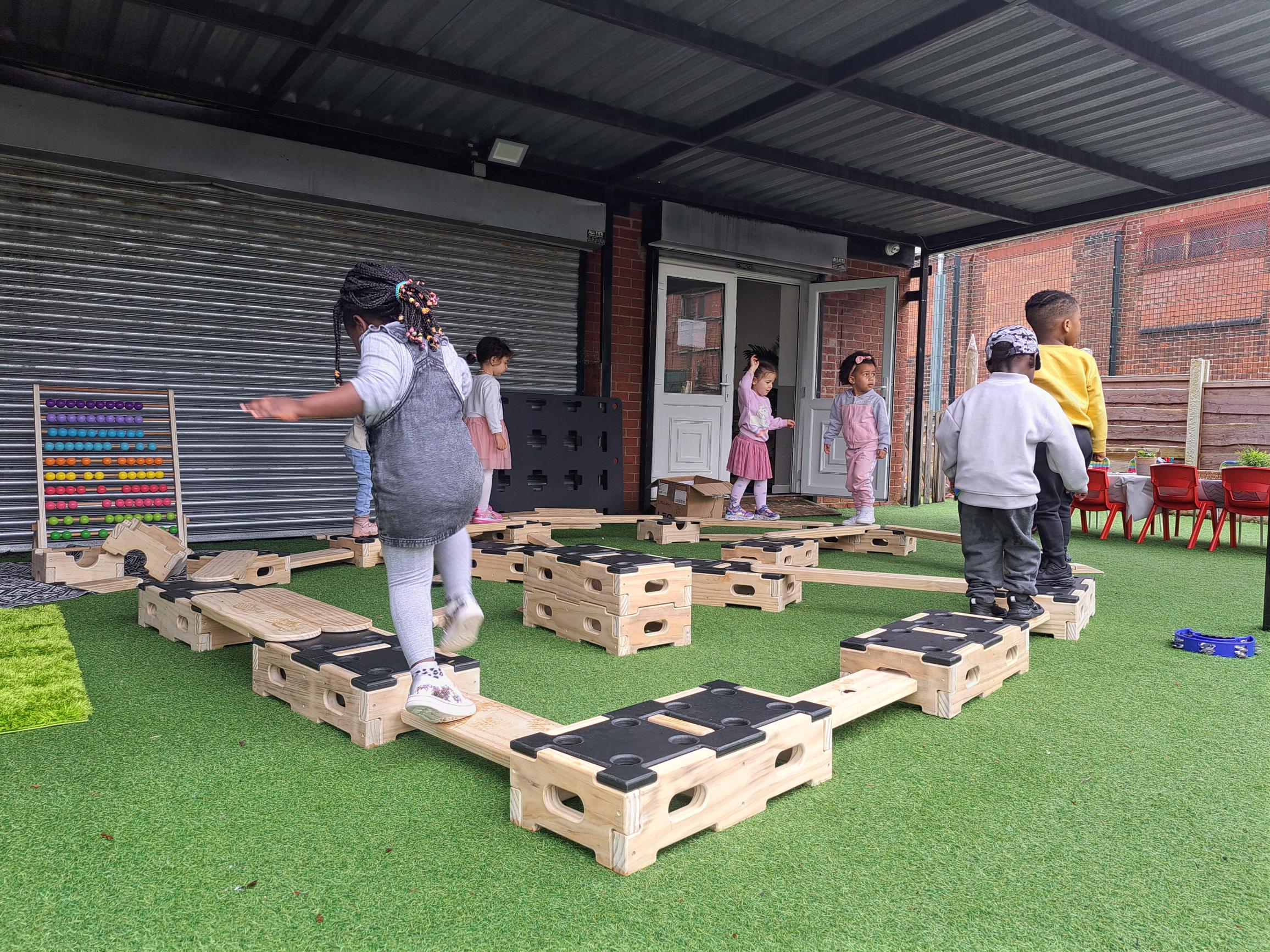 Children walking around a trail they have made with the play builder set