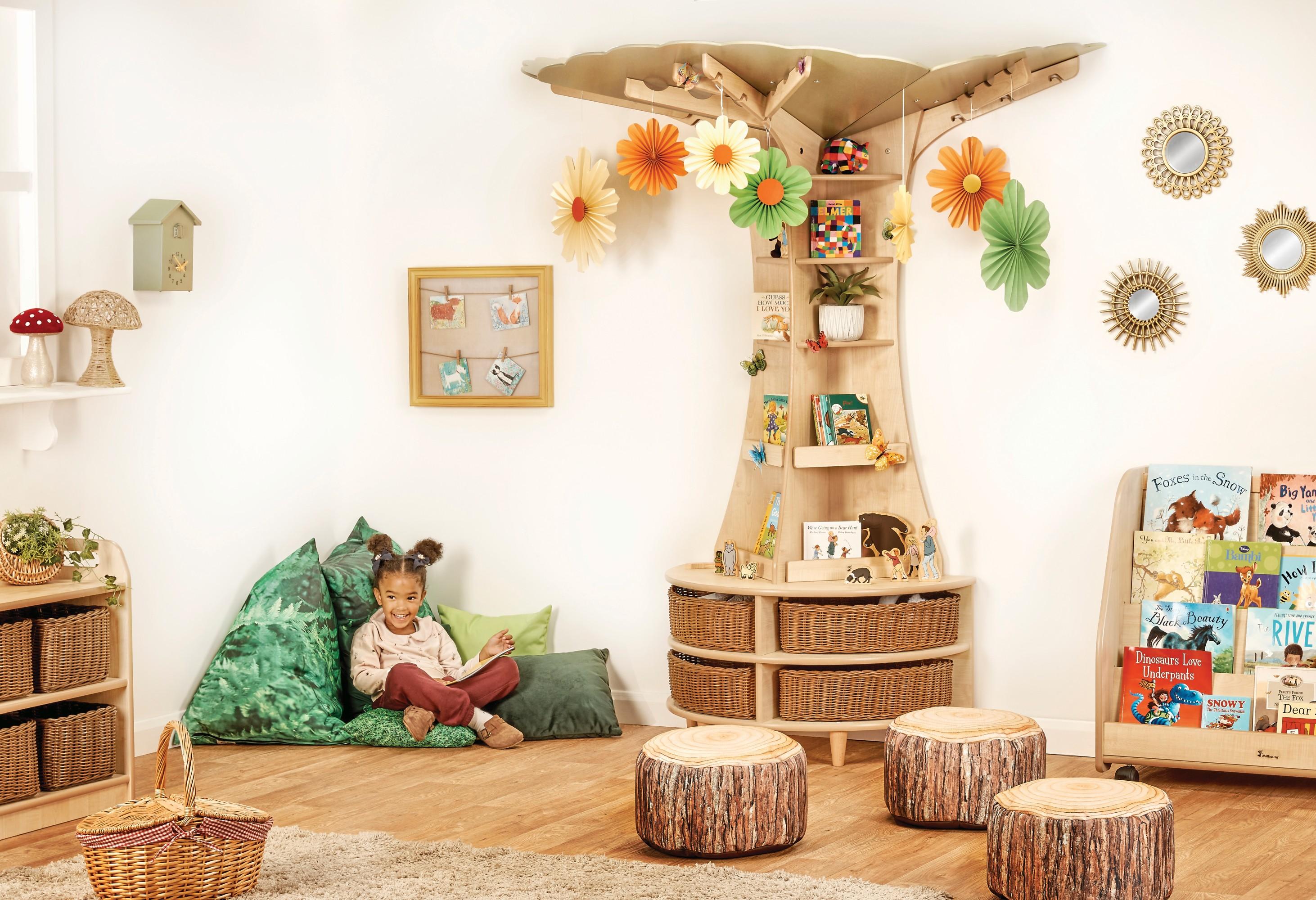 Wooden tree attached to wall with shelves and small seating. Children can sit and read or play.