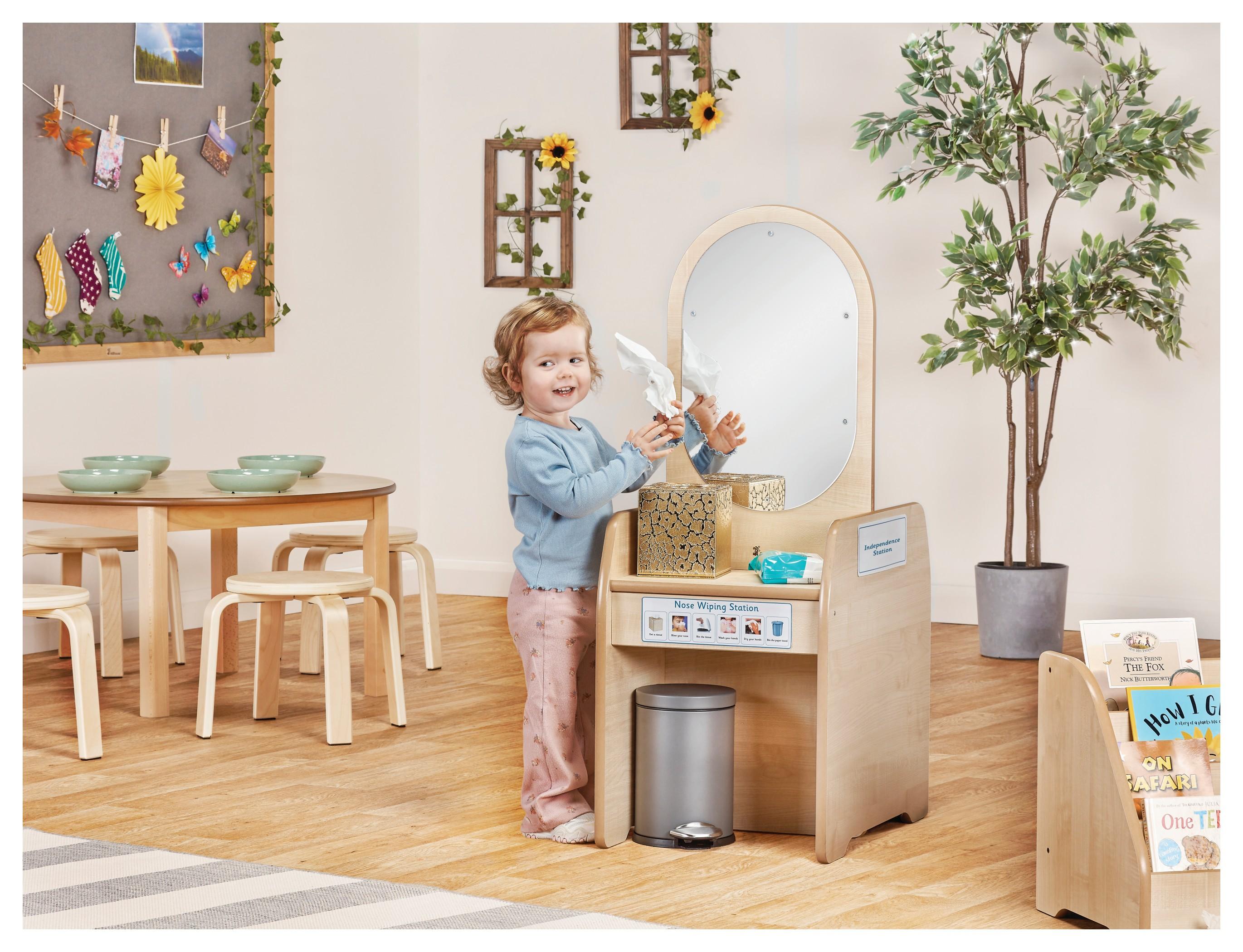 Child-height mirror with small shelves. Children can practice dressing or washing hands.