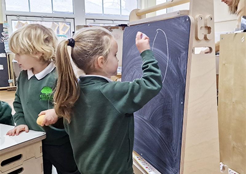 A school child drawing on the Indoor Art Easel.