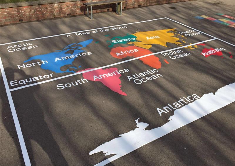 A thermoplastic playground marking of a world map with labels pointing out the continents, oceans and the equator. Each continent is a different colour, with the map being in an outlined box.