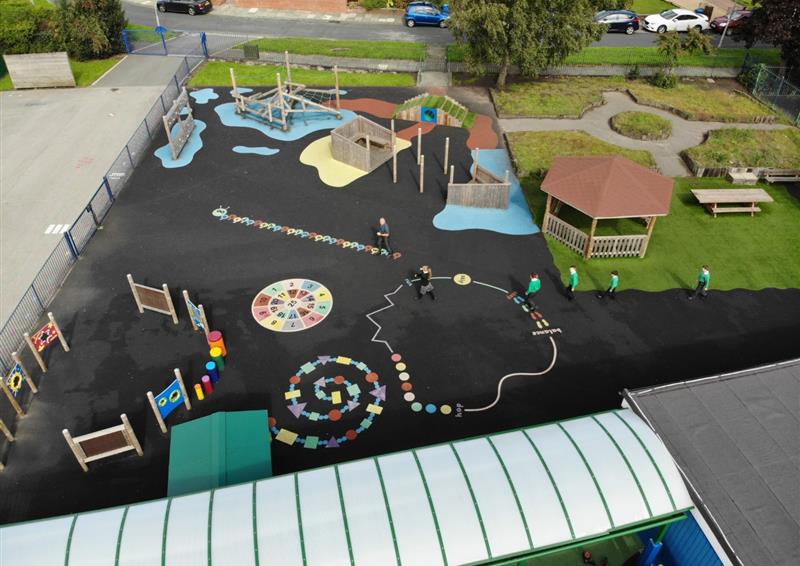 A variety of thermoplastic playground markings can be seen on a black tarmac surface. From multi-coloured spirals to line markings, the playground has a variety of different activities to do!