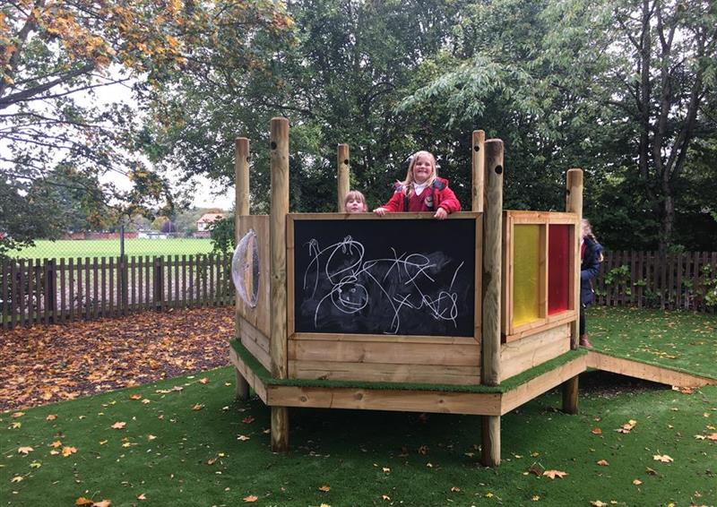 2 girls smiling and playing on our imagination station. 