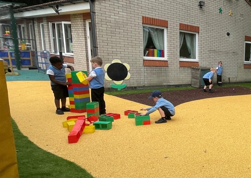 a view of our yellow wetpour surfacing with three little boys constructing blocks