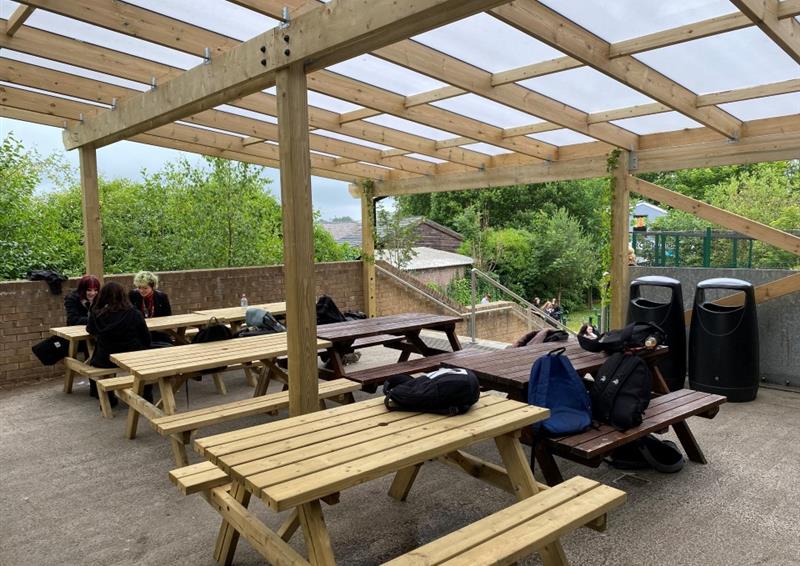timber picnic tables underneath the timber canopy with polycarbonate roofing