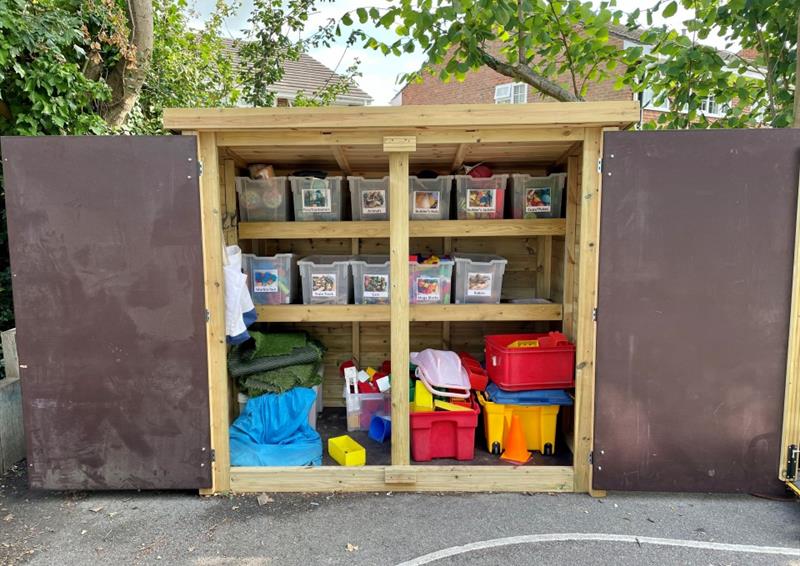 an organised outdoor cupboard without doors showing clear plastic storage boxes and multiple multi-coloured options in the bottom