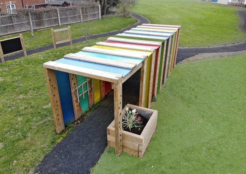 A birdseye view of a sensory tunnel with a planter on one side