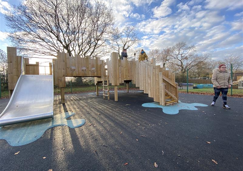 a front view of our bespoke play castle, on the left side there is a giant slide and on the right there are stairs.