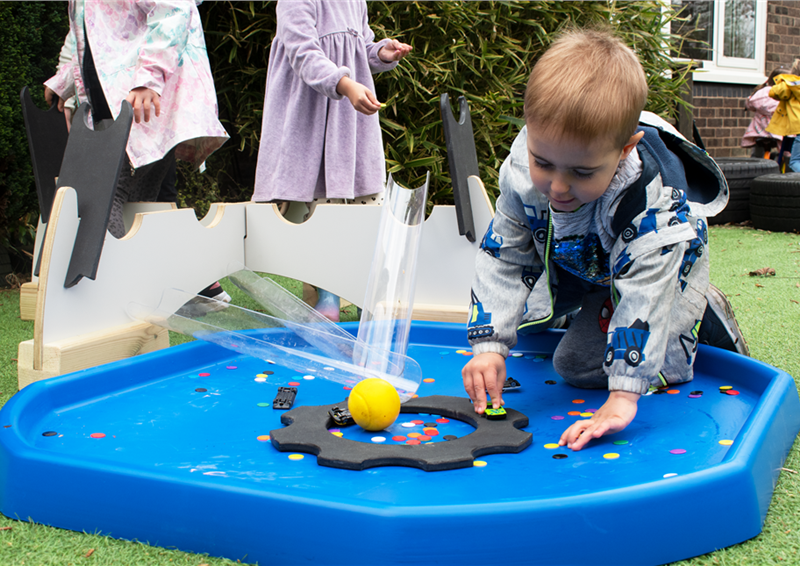 a young boy playing with the movable tuff spot tray