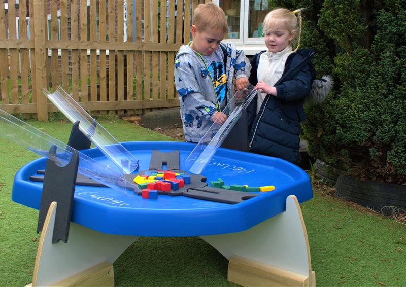 2 children playing on the tuff spot trays