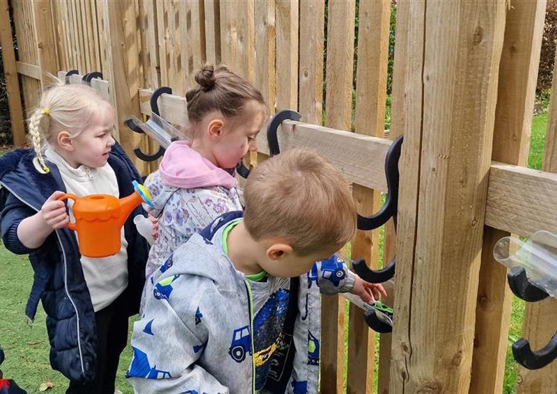 3 children playing on the water channel hooks